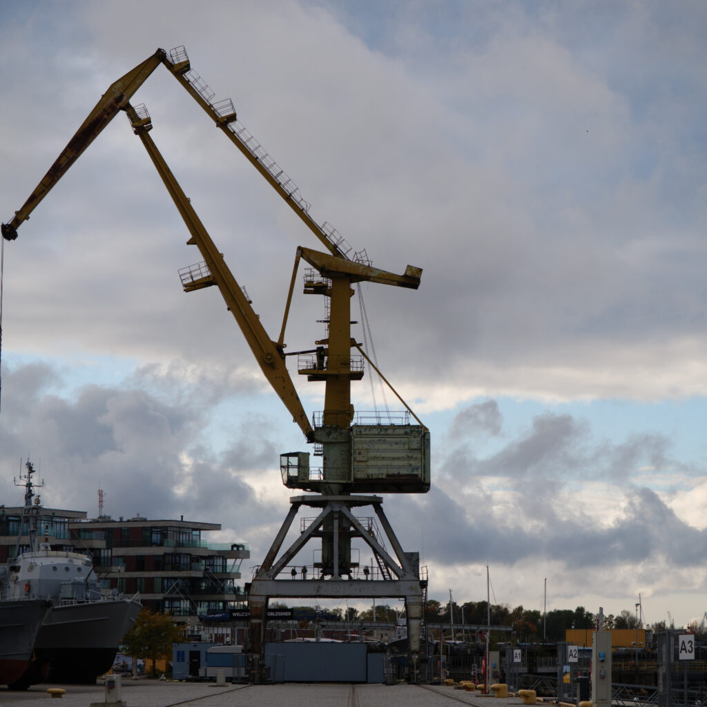 Suur kollane kraana sadamas pilvise taeva all.