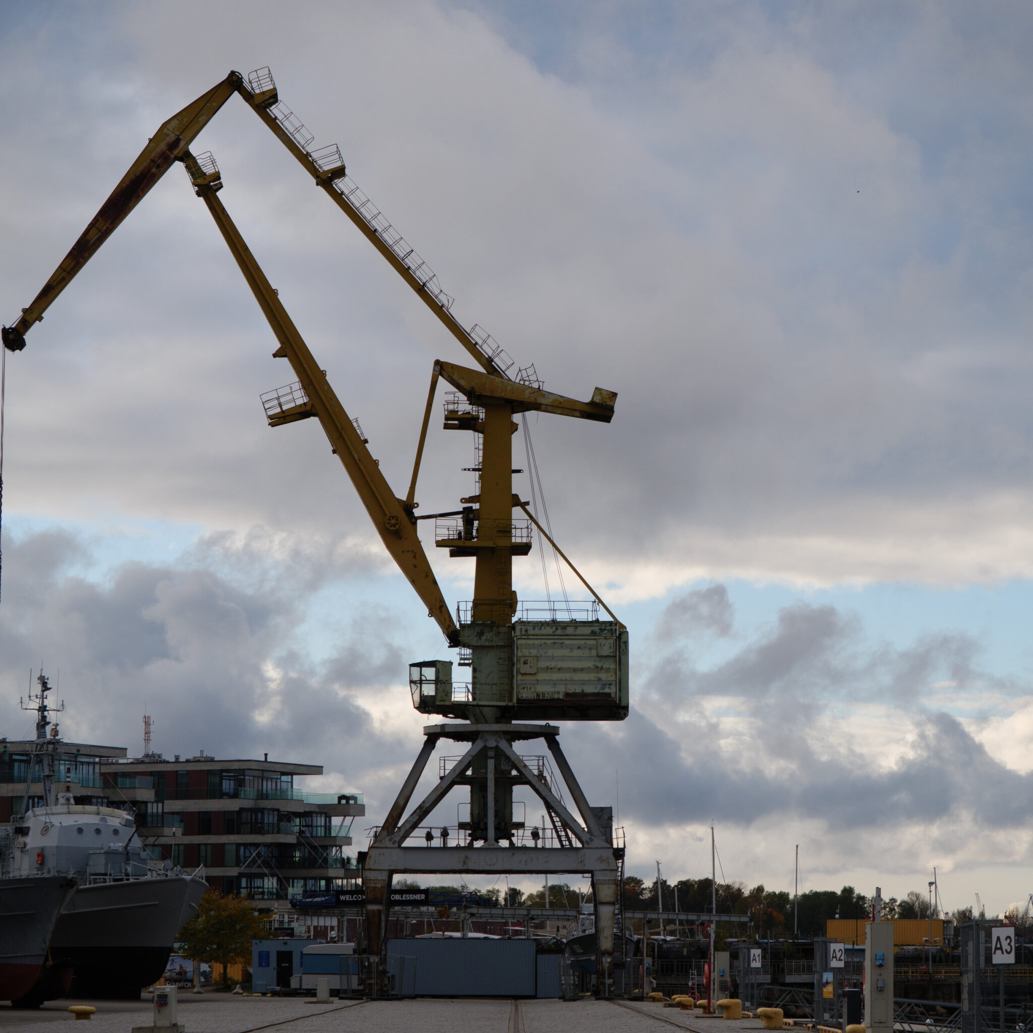 Suur kollane kraana sadamas pilvise taeva all.
