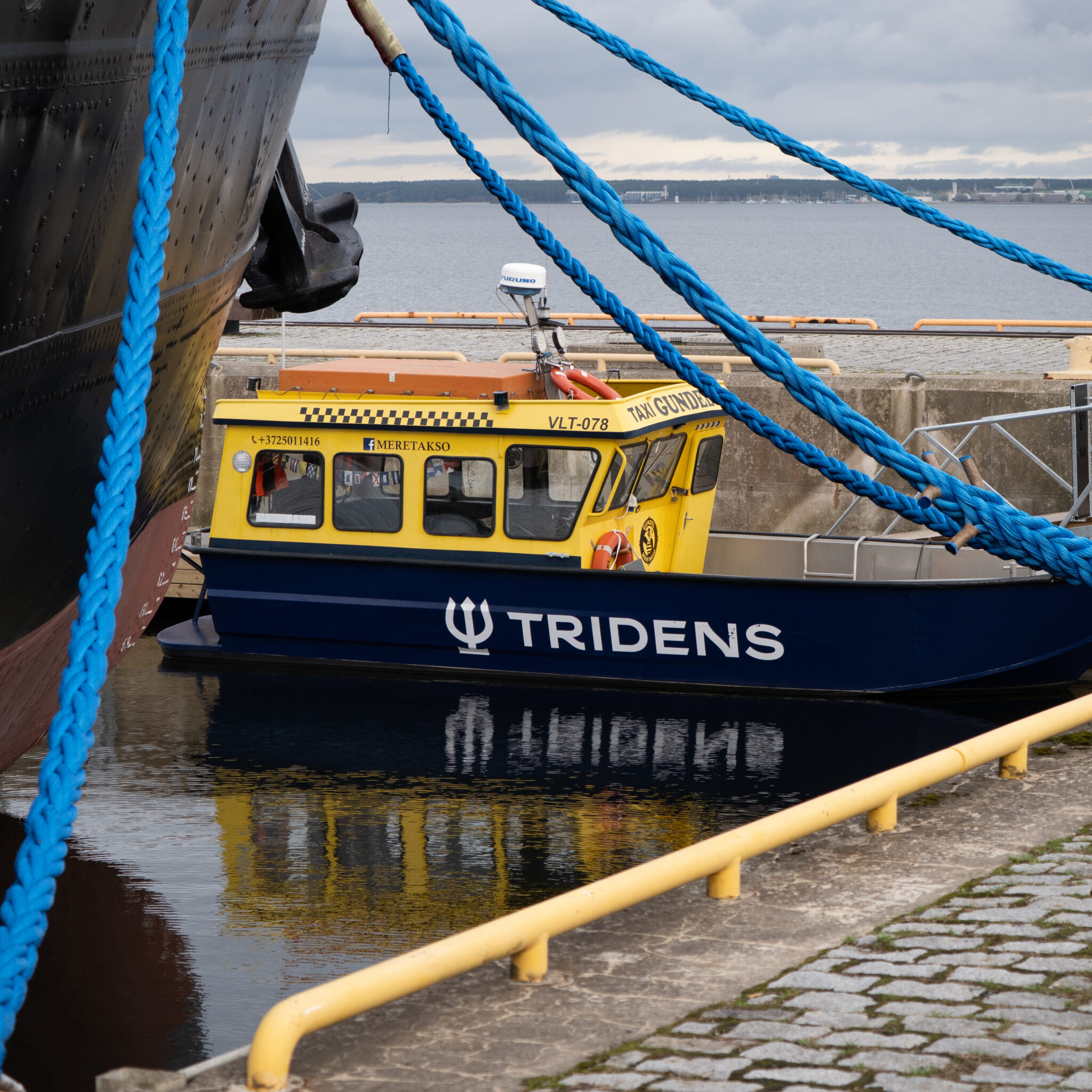 Kollane ja sinine paat kirjaga Tridens.