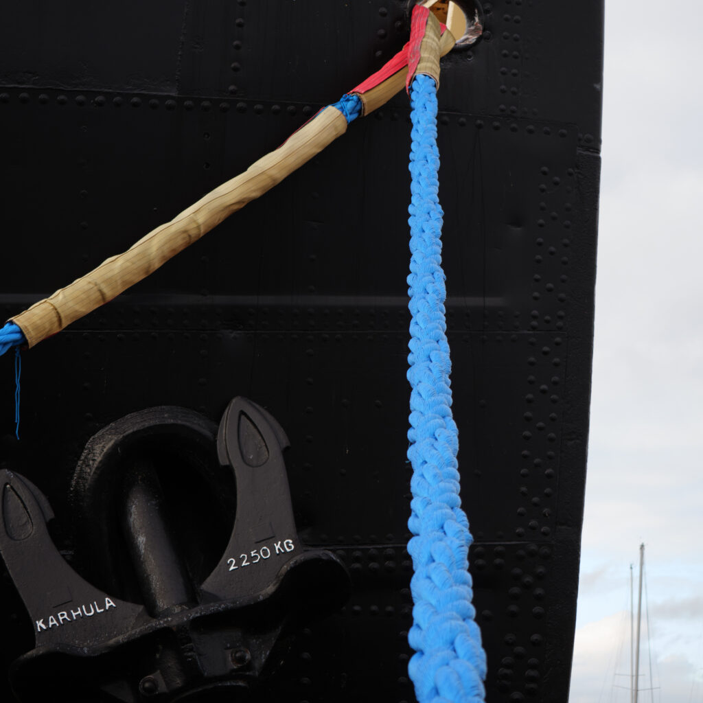 Must laev sinise köie ja ankruga.