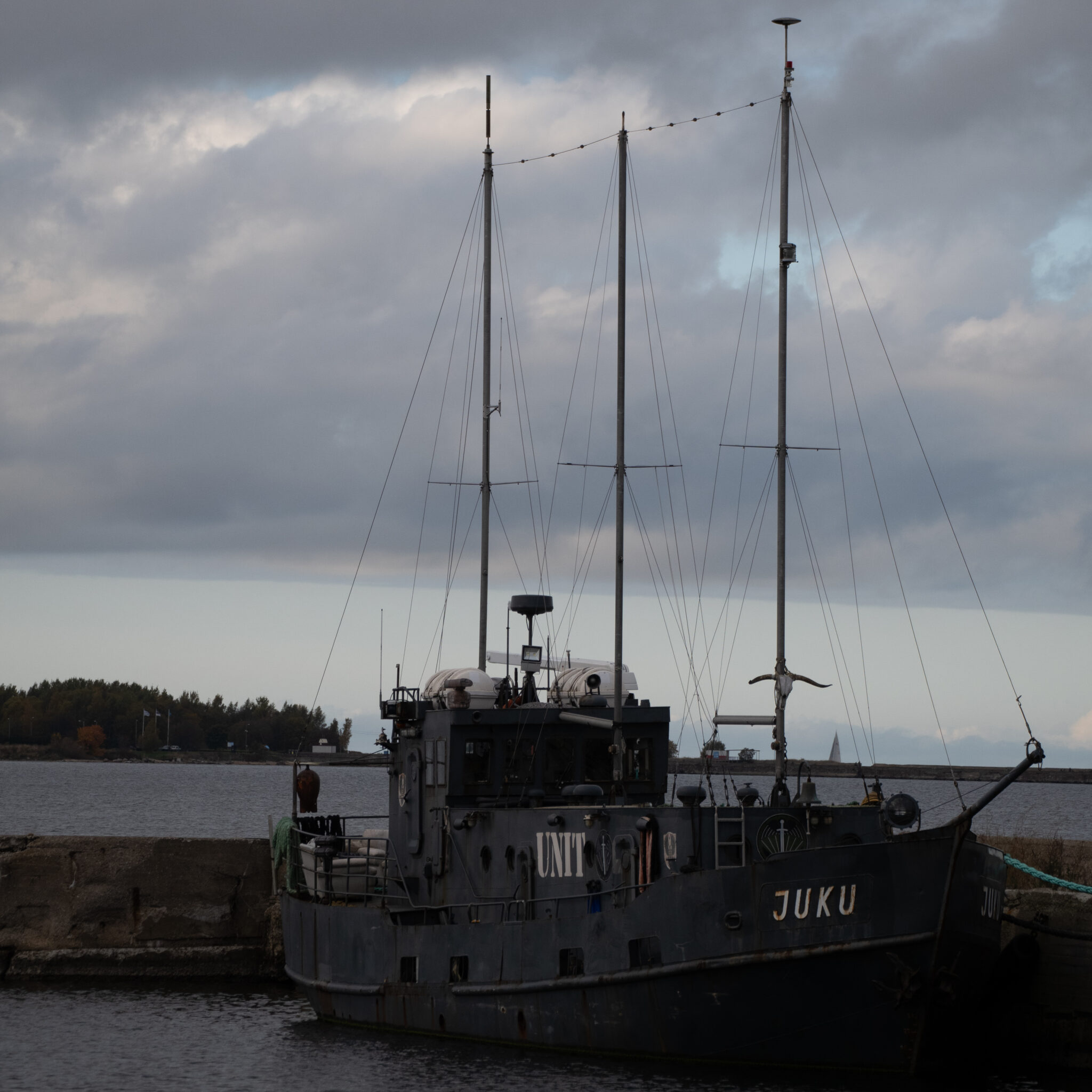 Sildunud paat kirjaga UNIT ja JUKU pilvise taeva taustal.