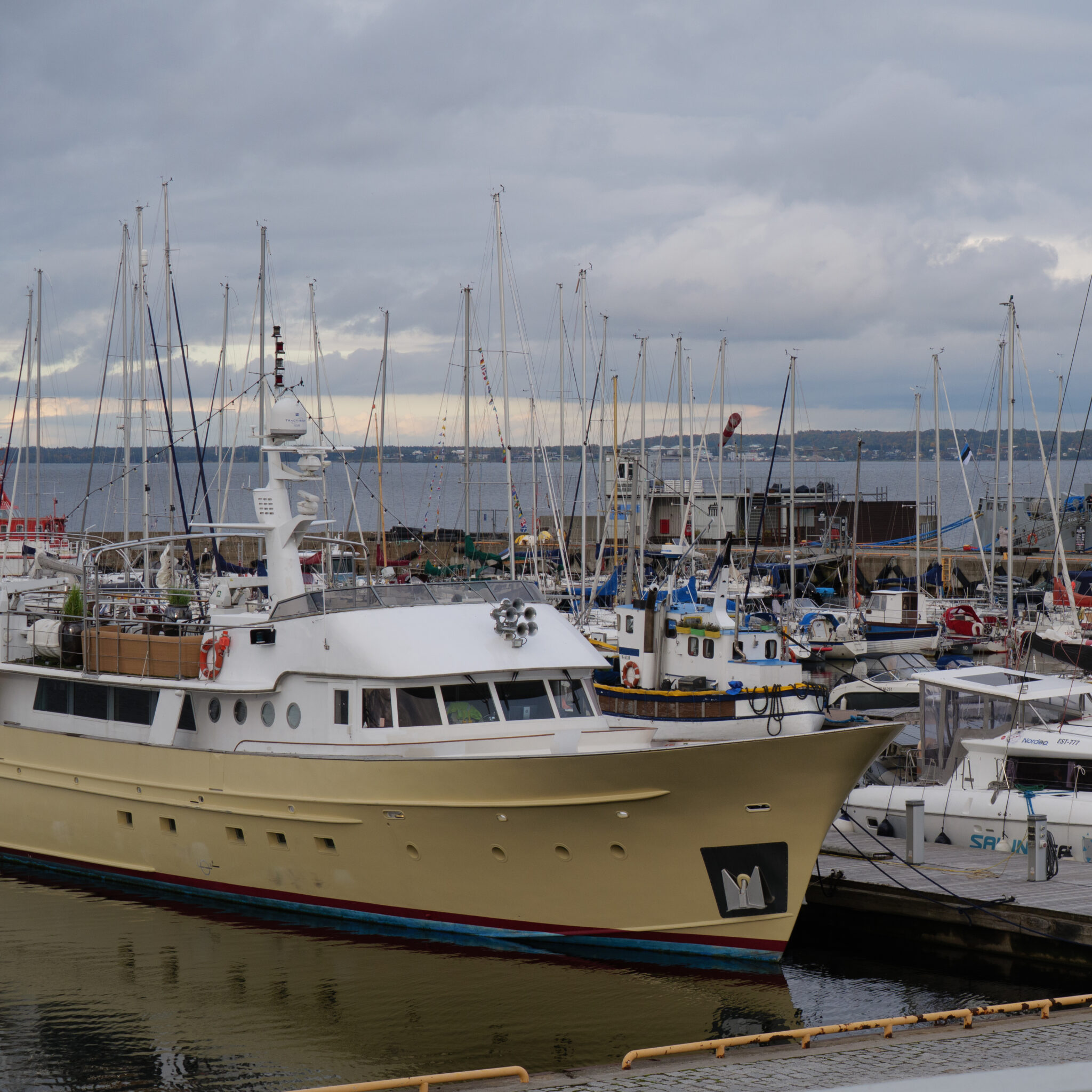 Suur kollane paat dokis sadamas mastide vahel.