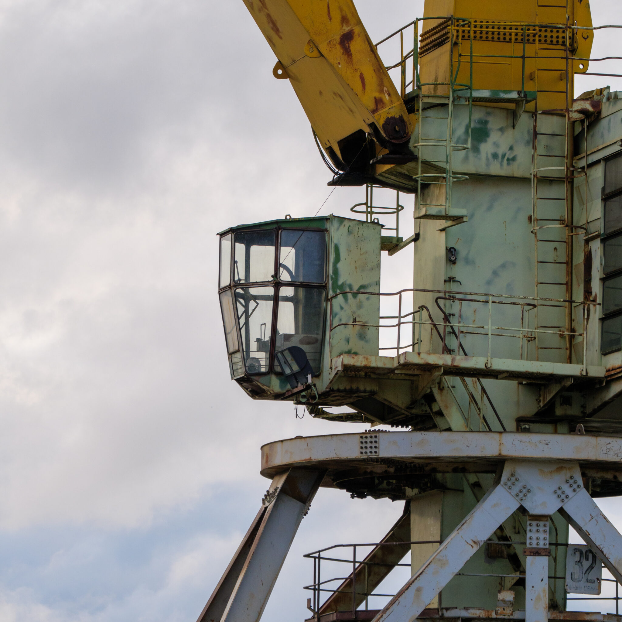 Vana roostes kraana kollase noole ja sinakasrohelise kabiiniga.