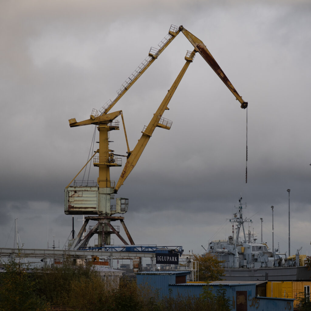 Suur kollane kraana laevatehases pilvise taeva all.