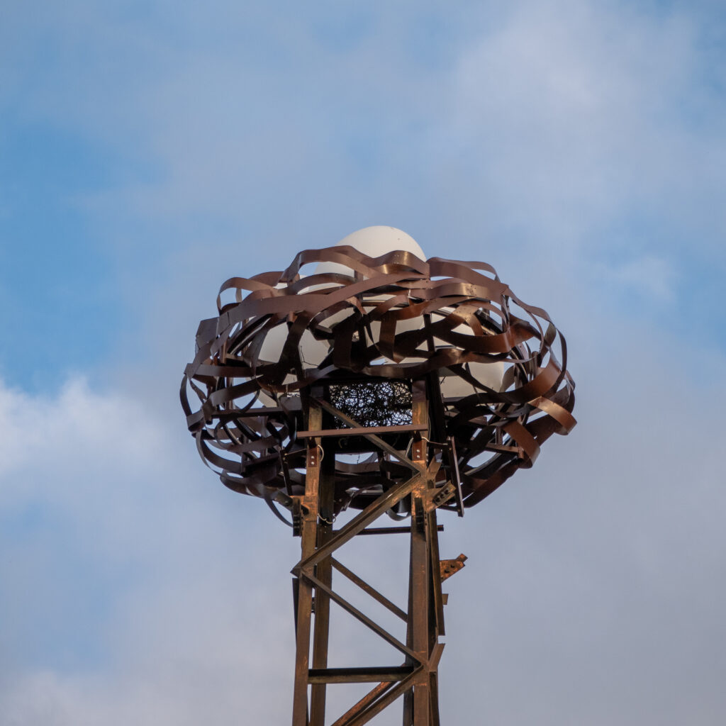 Unikaalne metallkonstruktsioon valge kupliga sinise taeva taustal.