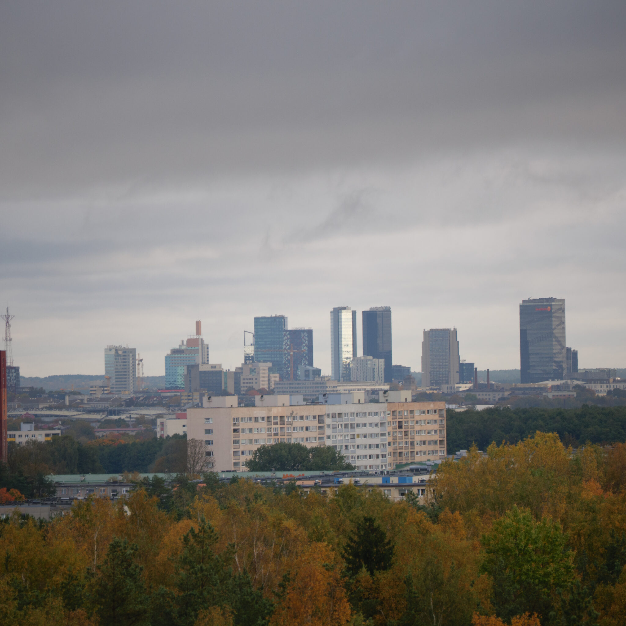 Linnasiluett sügiseste puudega ja pilvise taevaga.