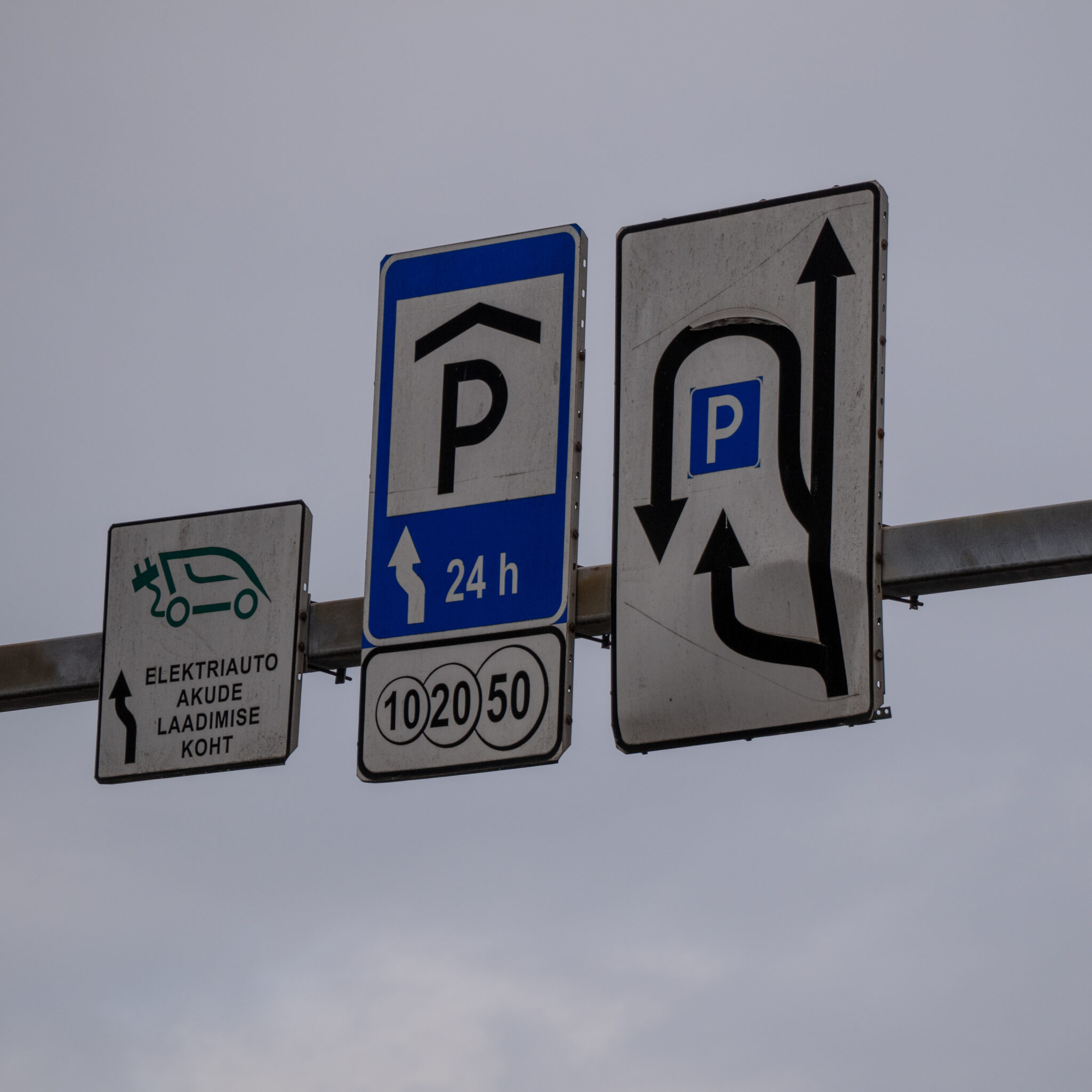 Mitmed liiklusmärgid, nende seas elektriauto laadimispunkti märk.