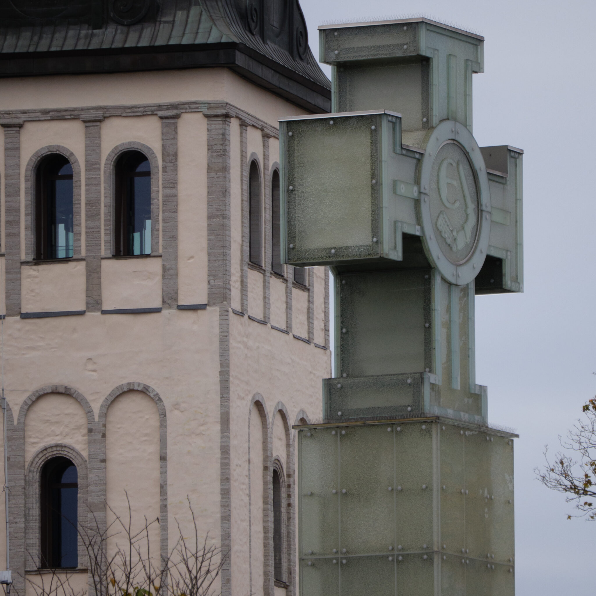 Kõrge roheline ristikujuline konstruktsioon hoone kõrval.