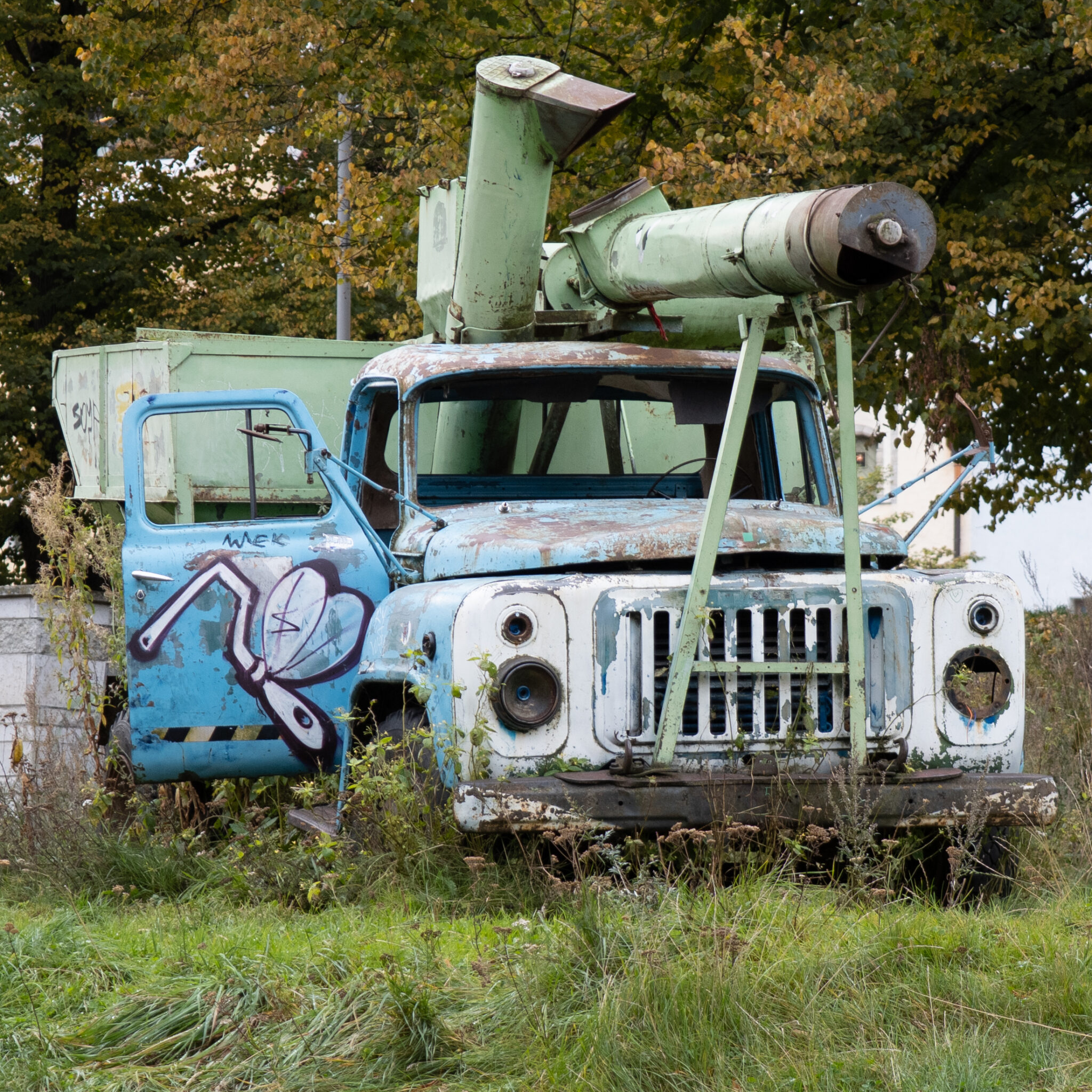 Vana roostes veoauto graffitiga ja rohelise seadeldisega katusel.
