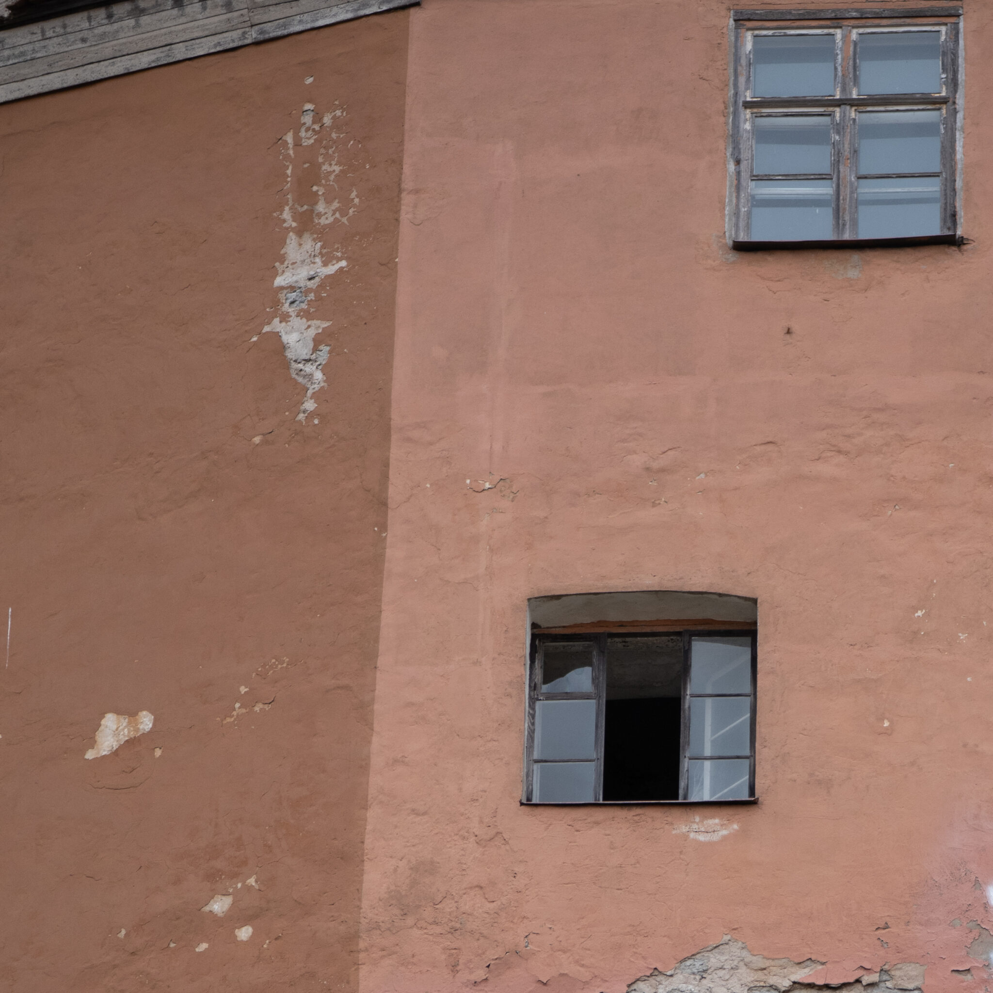 Vana oranž hoone kahe aknaga, millest üks on avatud.