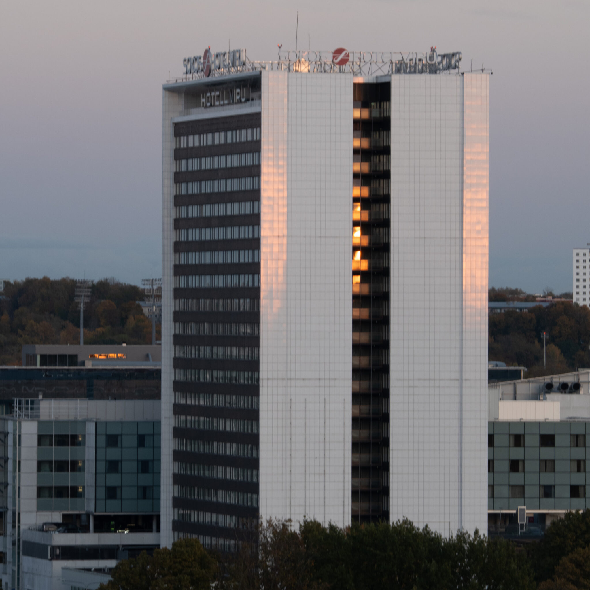 Kõrge moodne hoone logoga katusel.