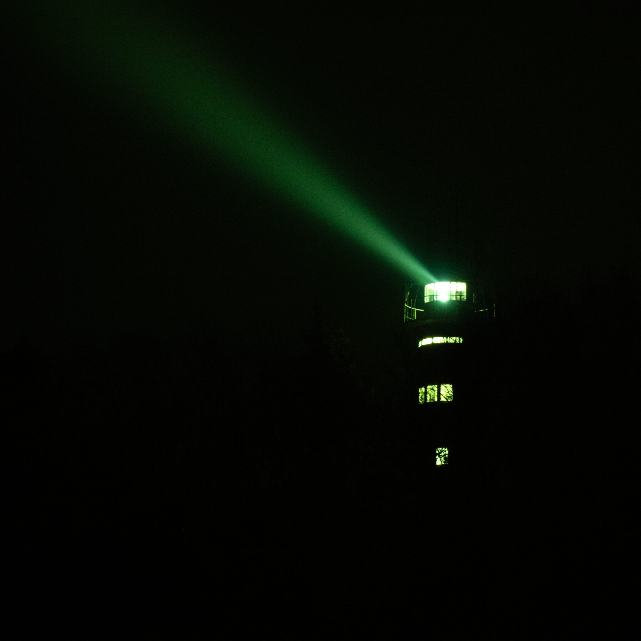 Roheline majakatuli öises pimeduses.