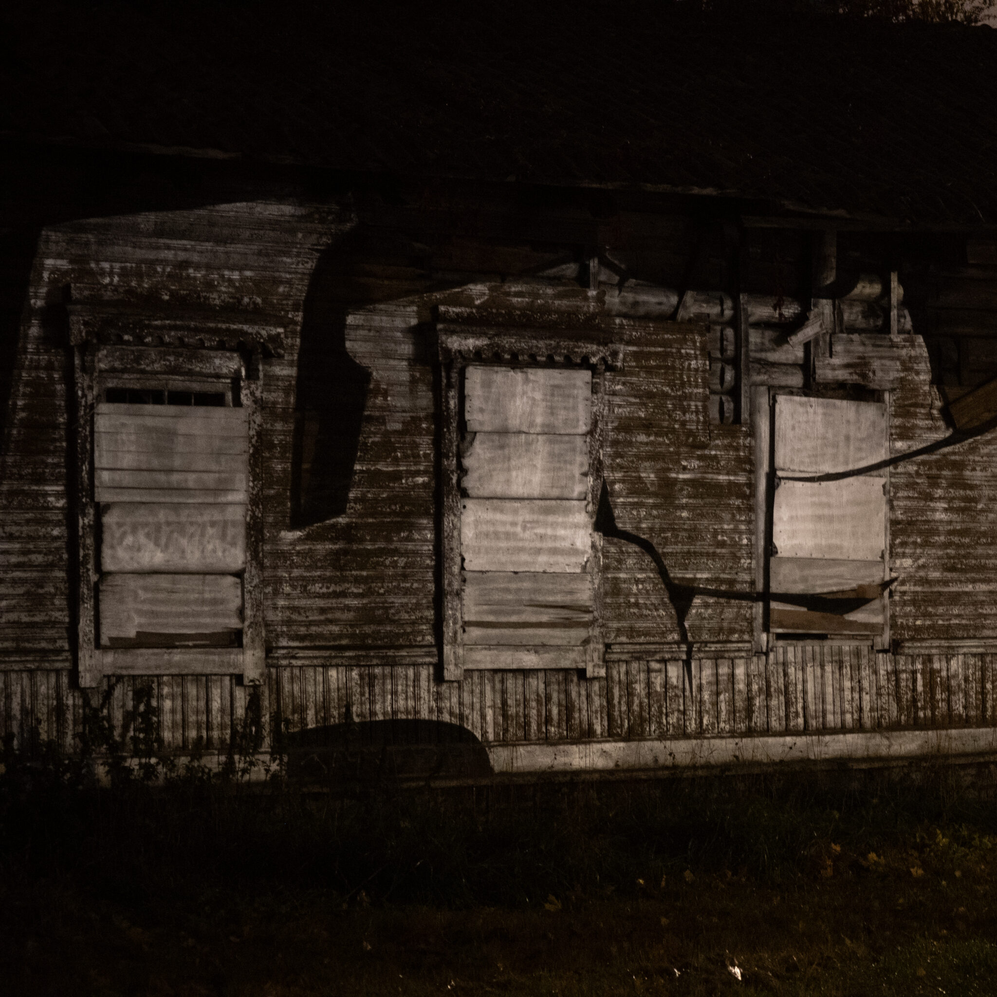 Vana kulunud laudadega kinni löödud akendega puumaja.