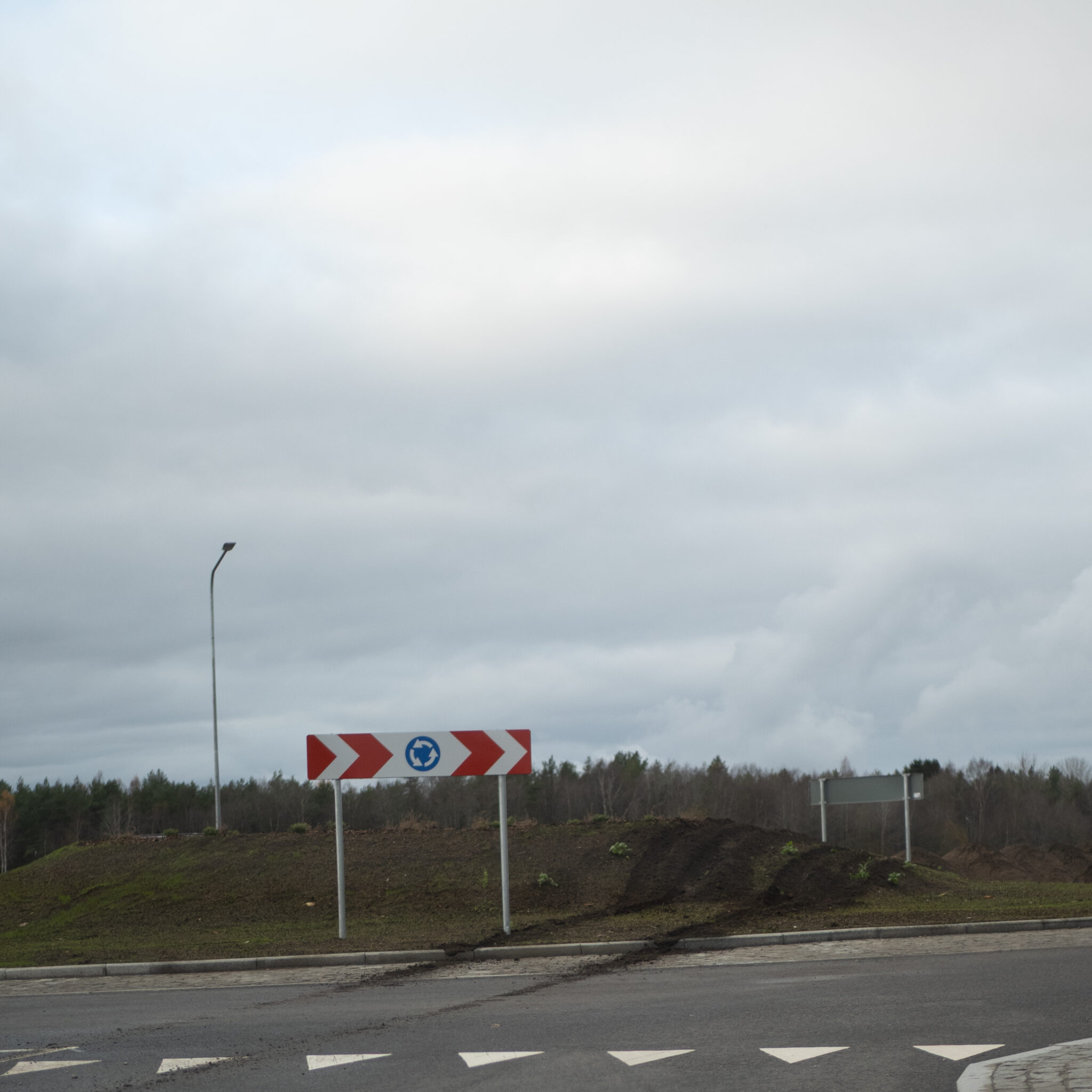 Noolete ja sinise sümboliga liiklusmärk künkal.