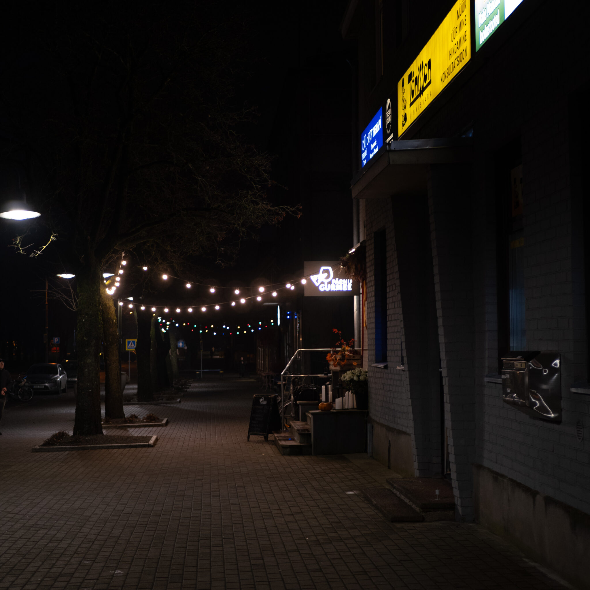 Vaikne öine tänav pidulike tulede ja kohvikuga.