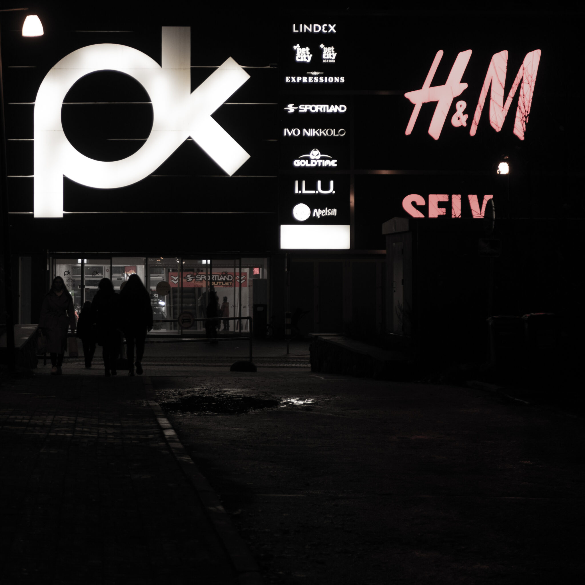 Inimesed kõnnivad öösel PK ja H&M poe eest mööda.