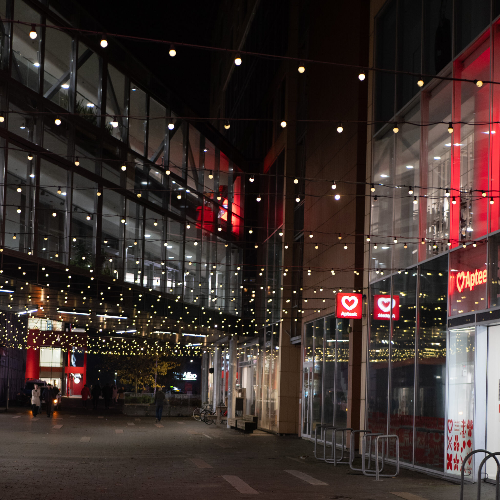 Südamekujulise logoga Apteek öösel valgustatud fassaadiga.