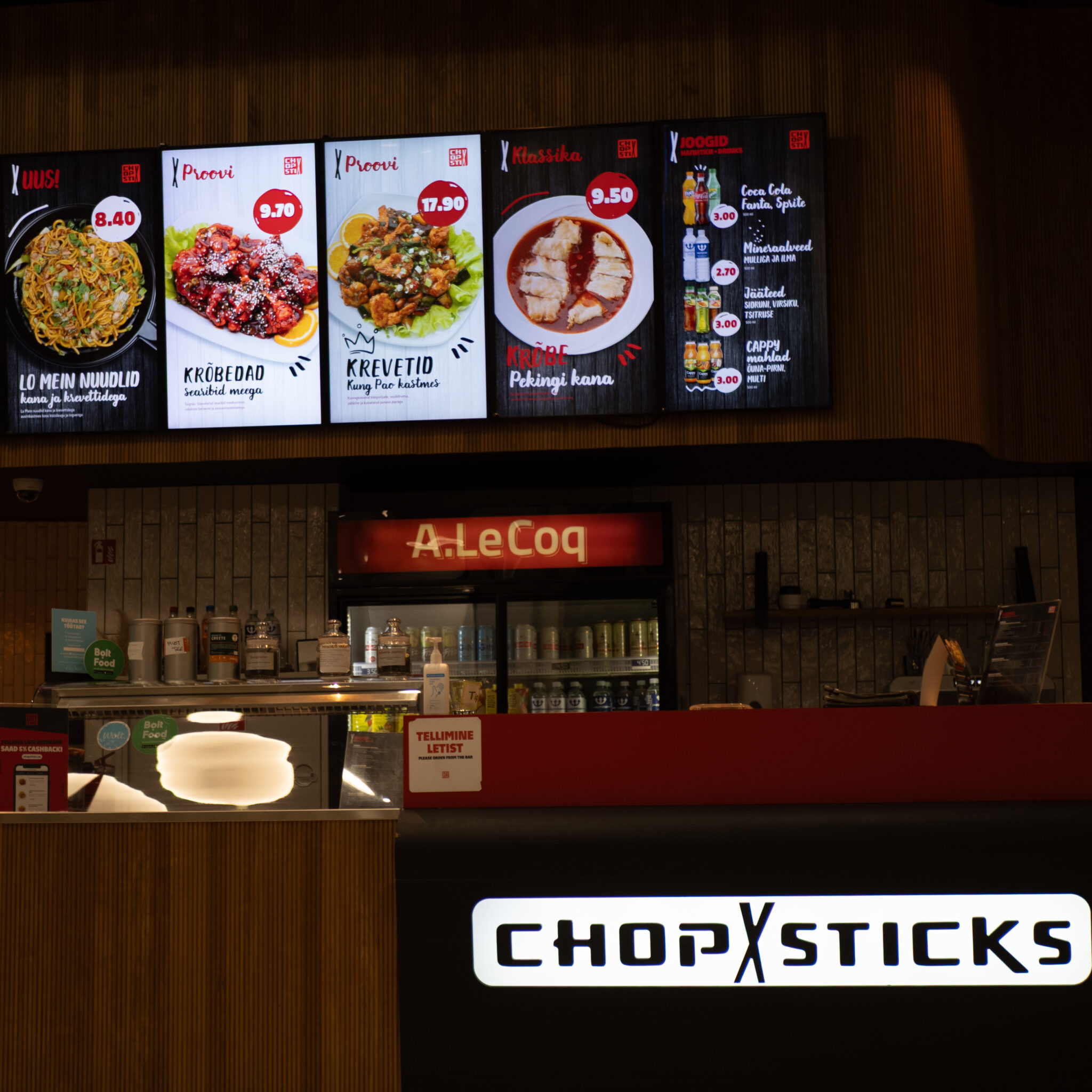 A Le Coq Chopsticks restoran menüü ja toidupiltidega ekraanidel.