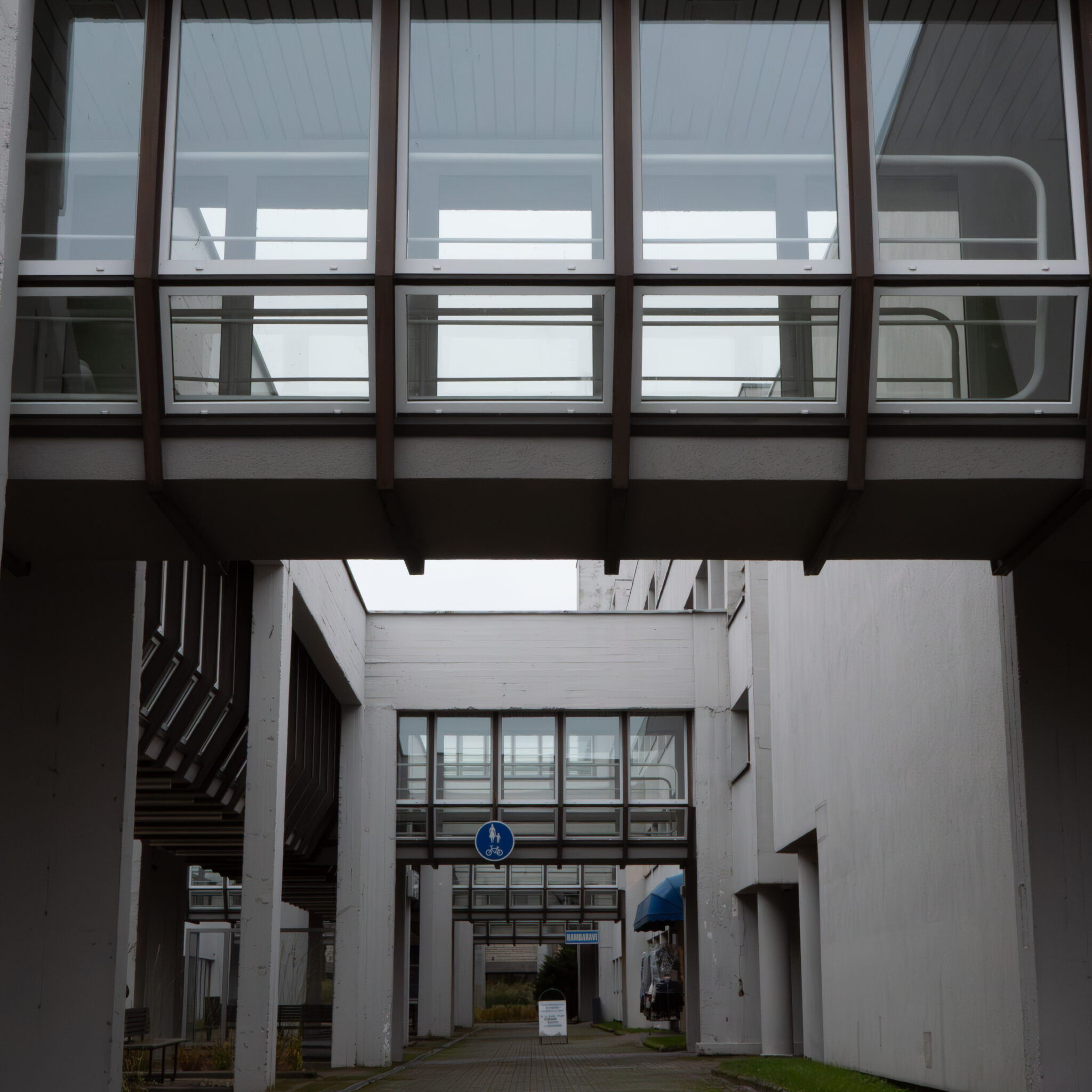 Moodne jalakäijate sild klaaspaneelide ja metallpiiretega.