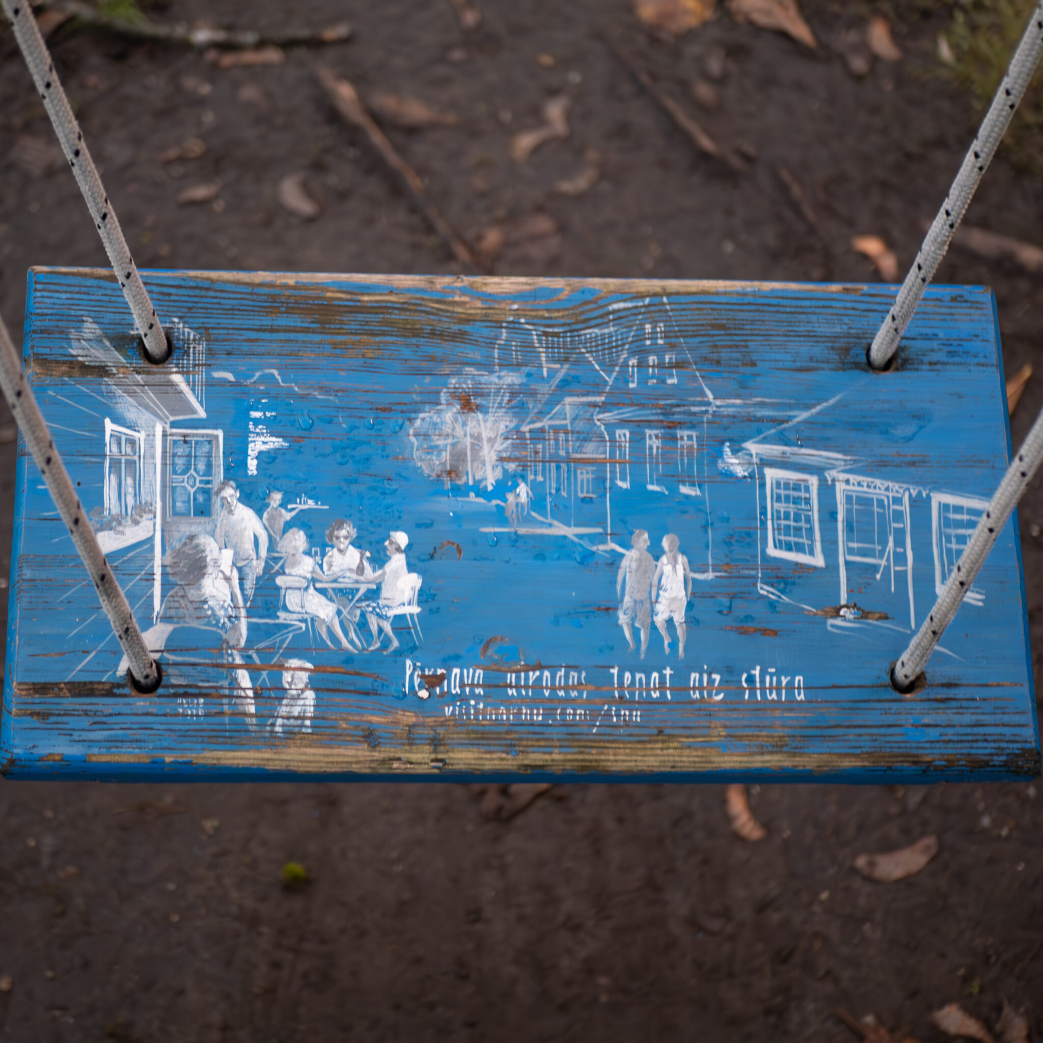 Sinine kiik valge joonistusega inimestest ja majadest.