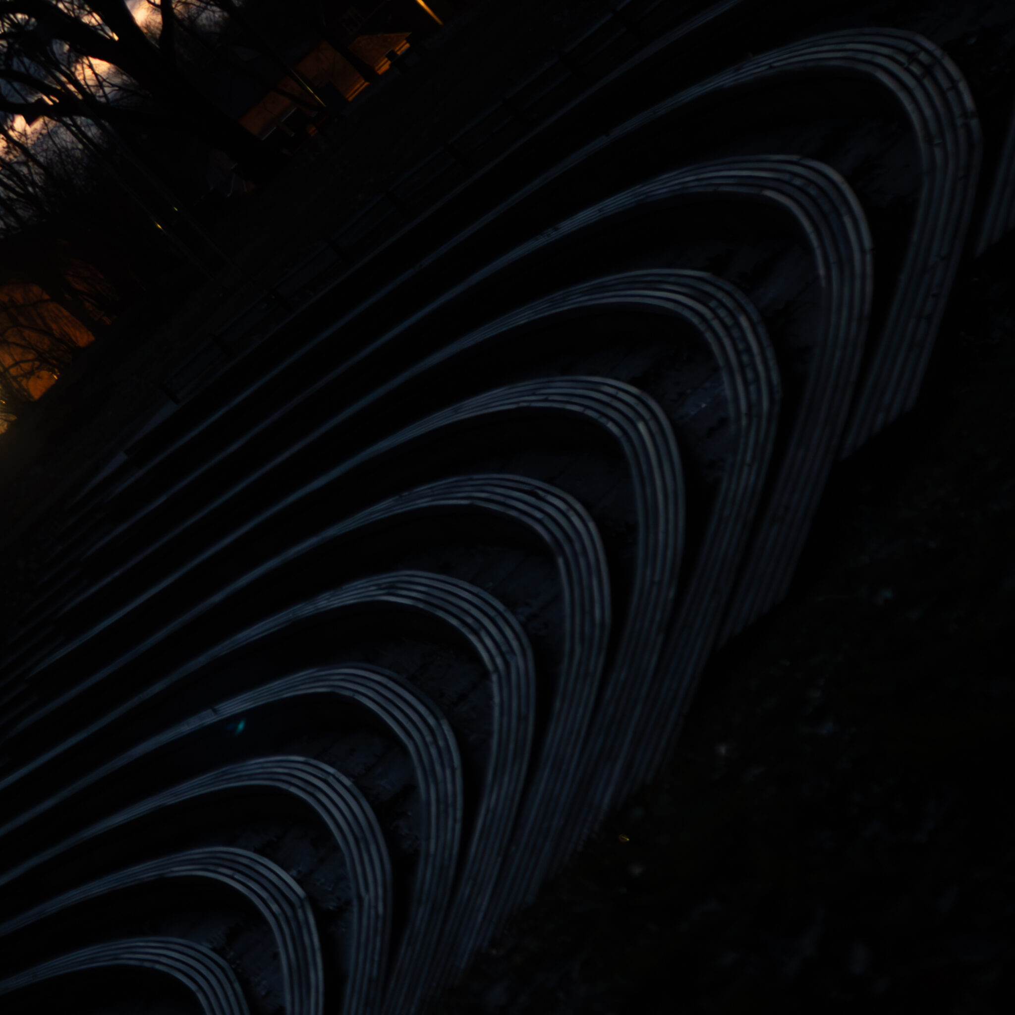 Rida kaarduvaid metallkaari pimedas väliruumis.