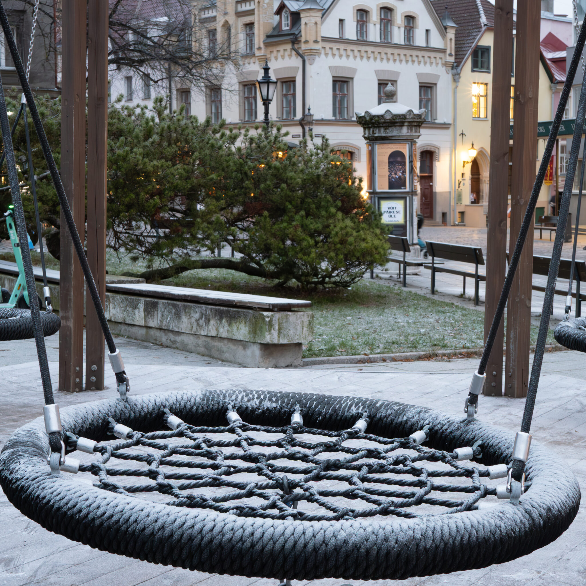 Lumega kaetud kiik Euroopa linnaväljakul.