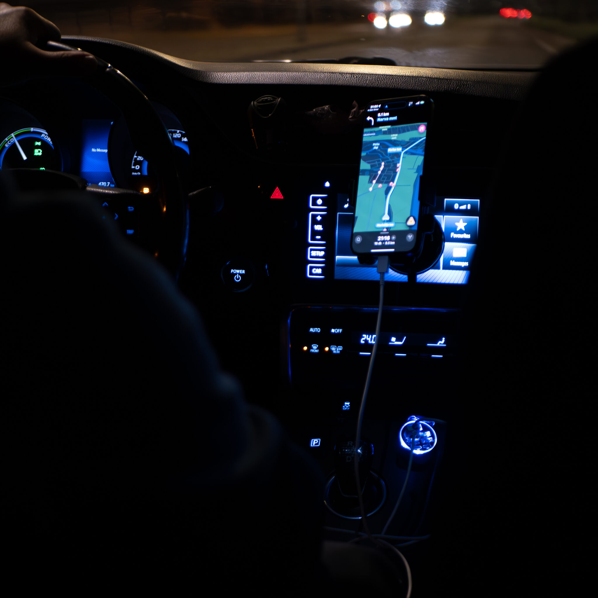 Inimene juhib autot, armatuurlauale kinnitatud telefoniga.