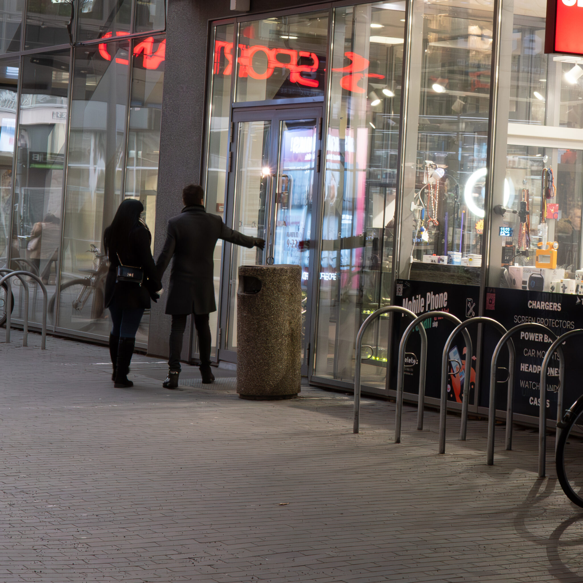 Paar siseneb neoonsildiga poodi.