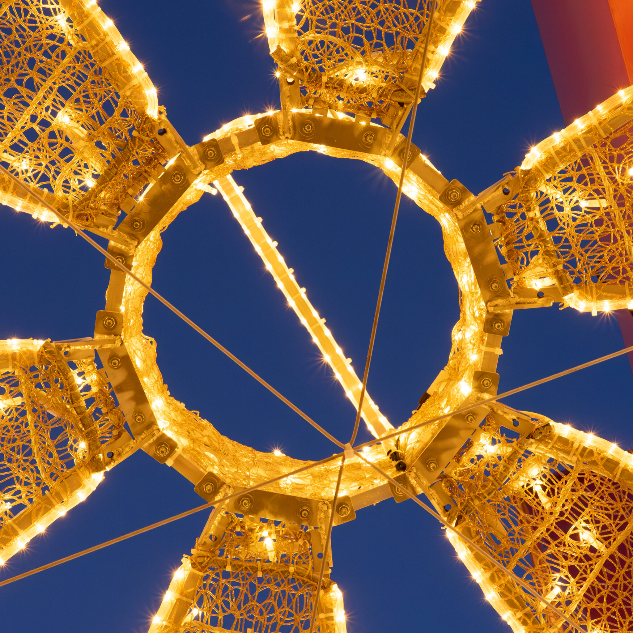 Kuldne detailne valgusinstallatsioon tumeda taeva taustal.