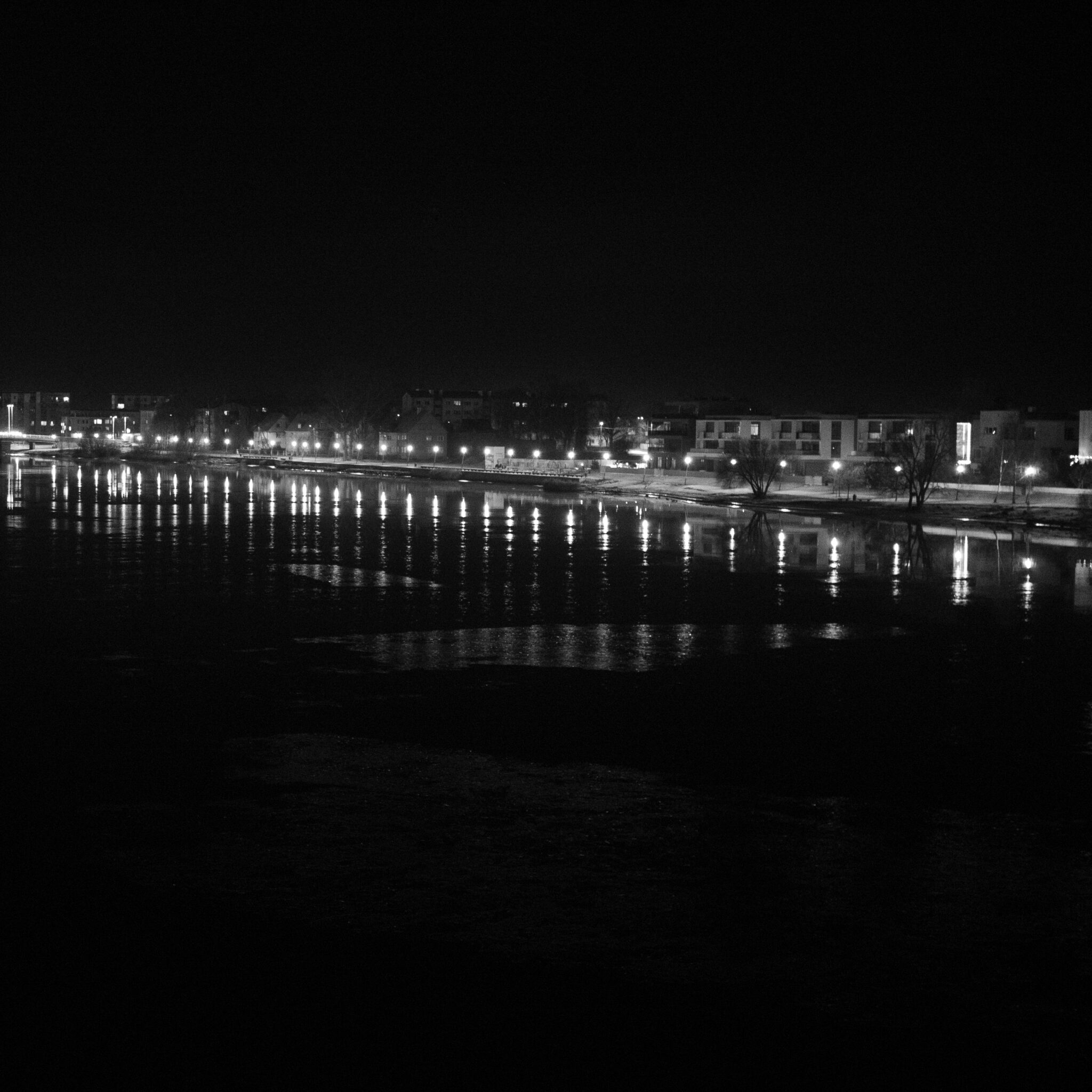 Öine linnavaade jõe ääres, peegeldused veepinnal.