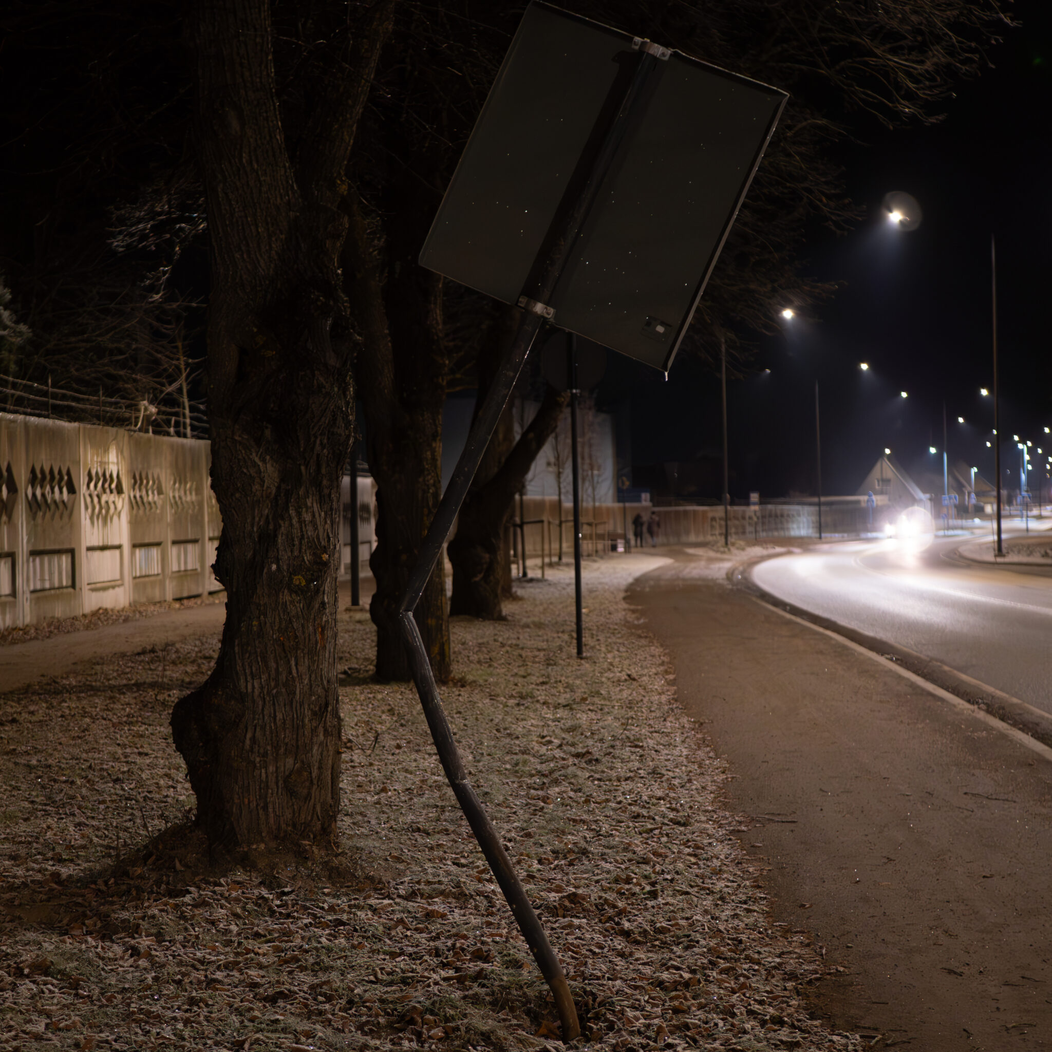 Öösel puu najale toetuv liiklusmärk.