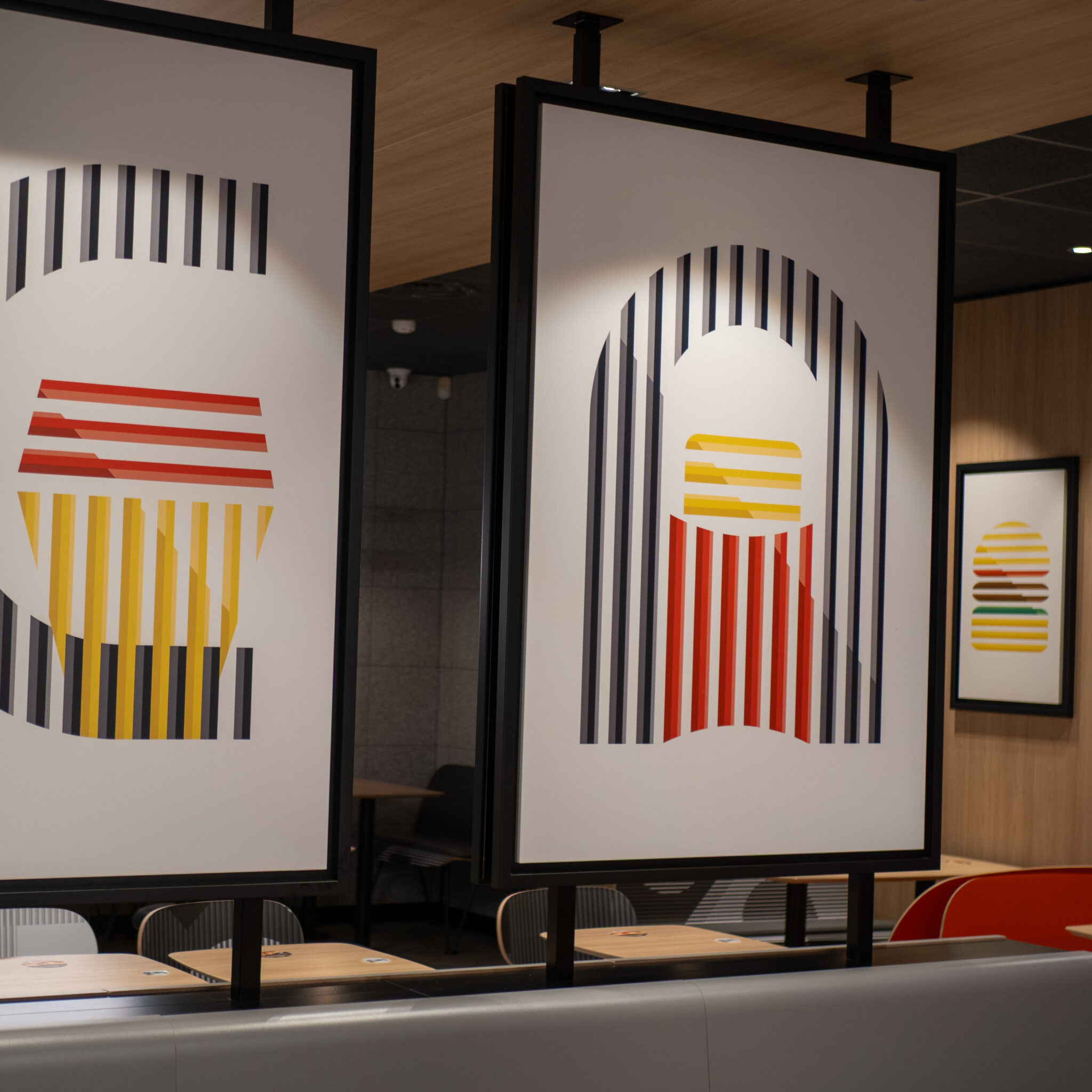 Restoranis kolm värvilist triibulist plakatit.