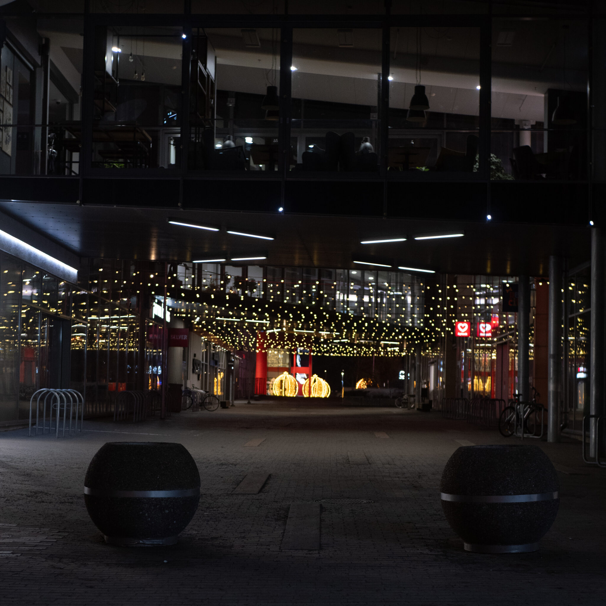 Tühi pime tänav pidulike tulede ja klaashoonega.