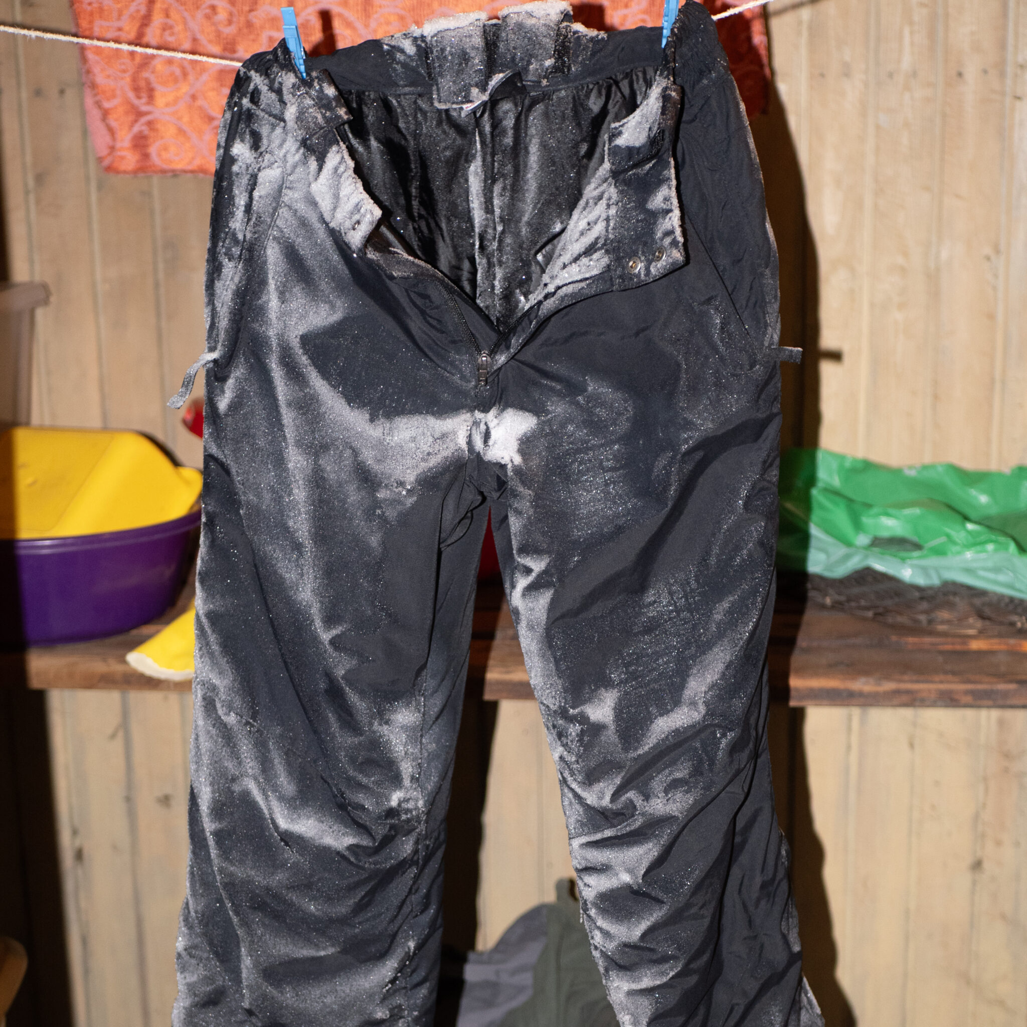 Mustad määrdunud püksid kuivatusnööril.