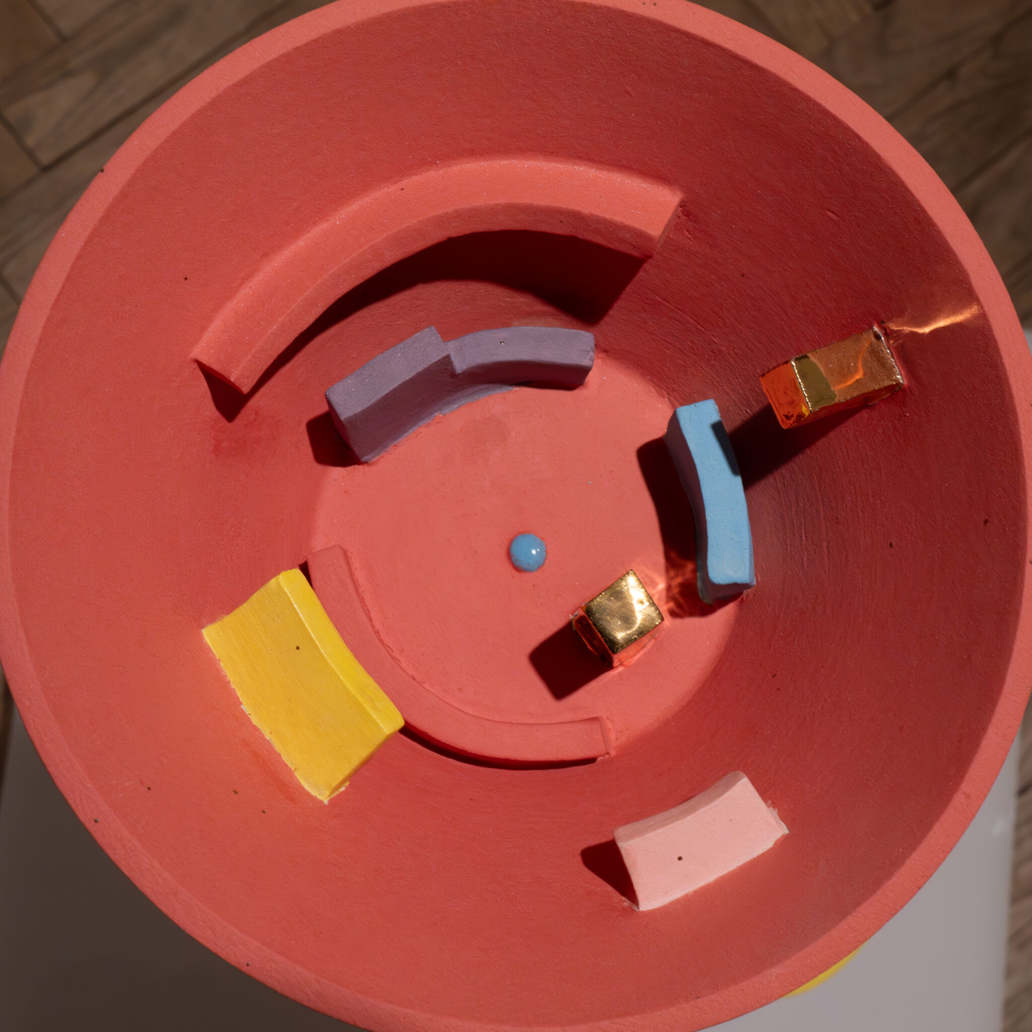 Värviline abstraktne skulptuur punase aluse ja geomeetriliste kujunditega.