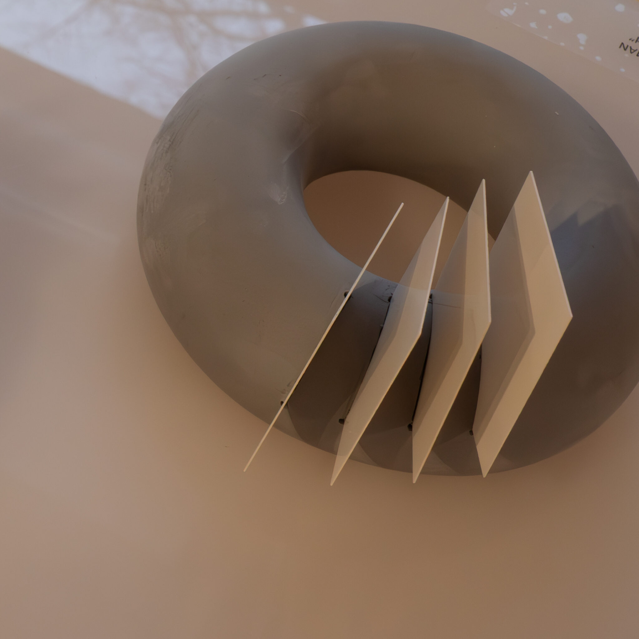 Hall ümmargune objekt valgete geomeetriliste kujunditega peal.