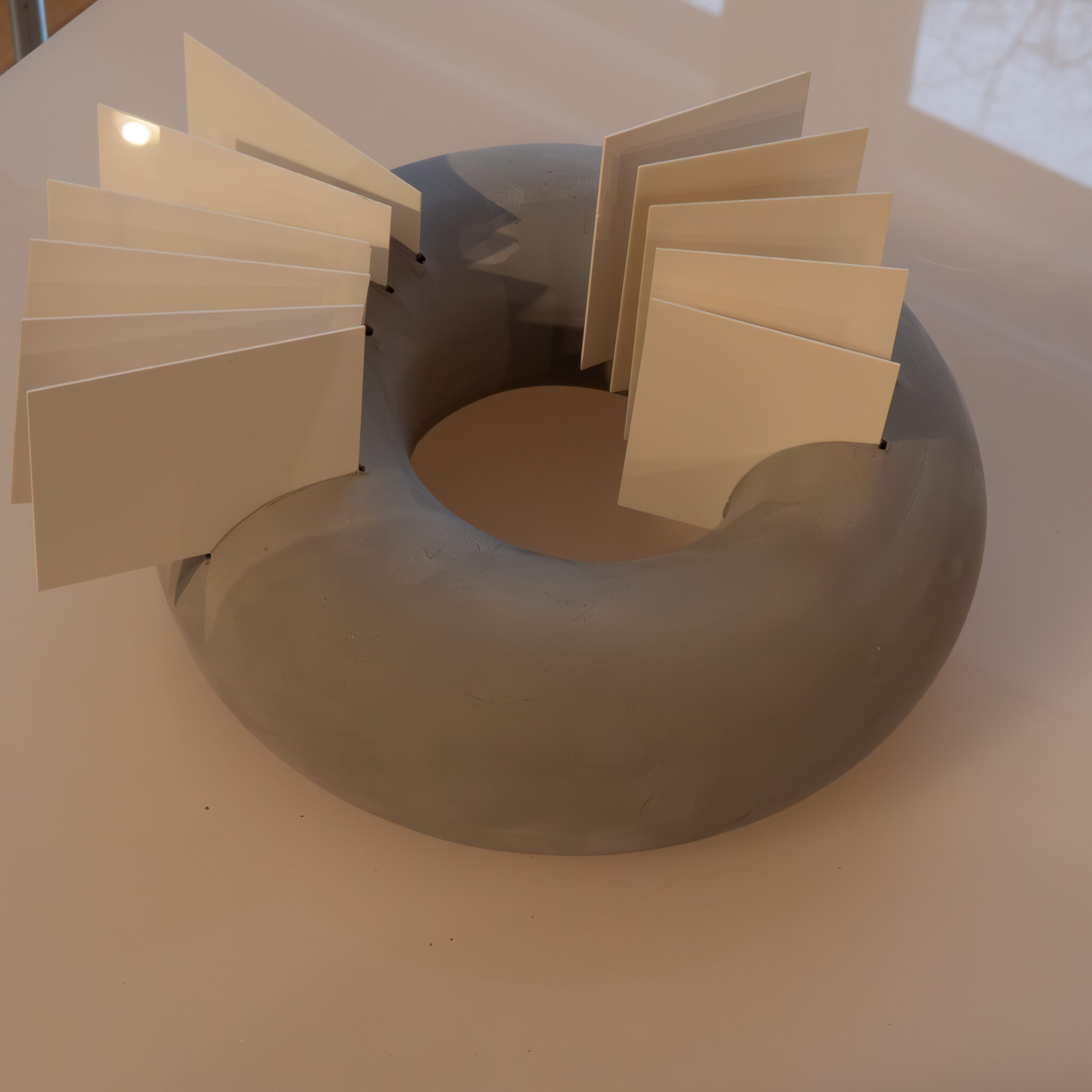 Ümmargune hall skulptuur valgete paneelidega külgedel.