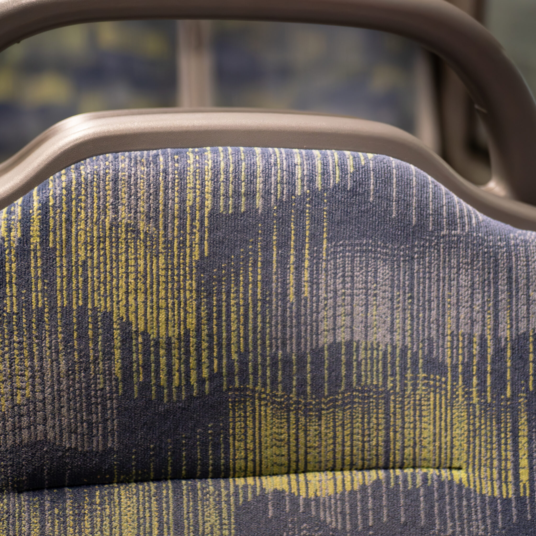 Lähivaade bussiistmest sinikollase mustriga kangaga.