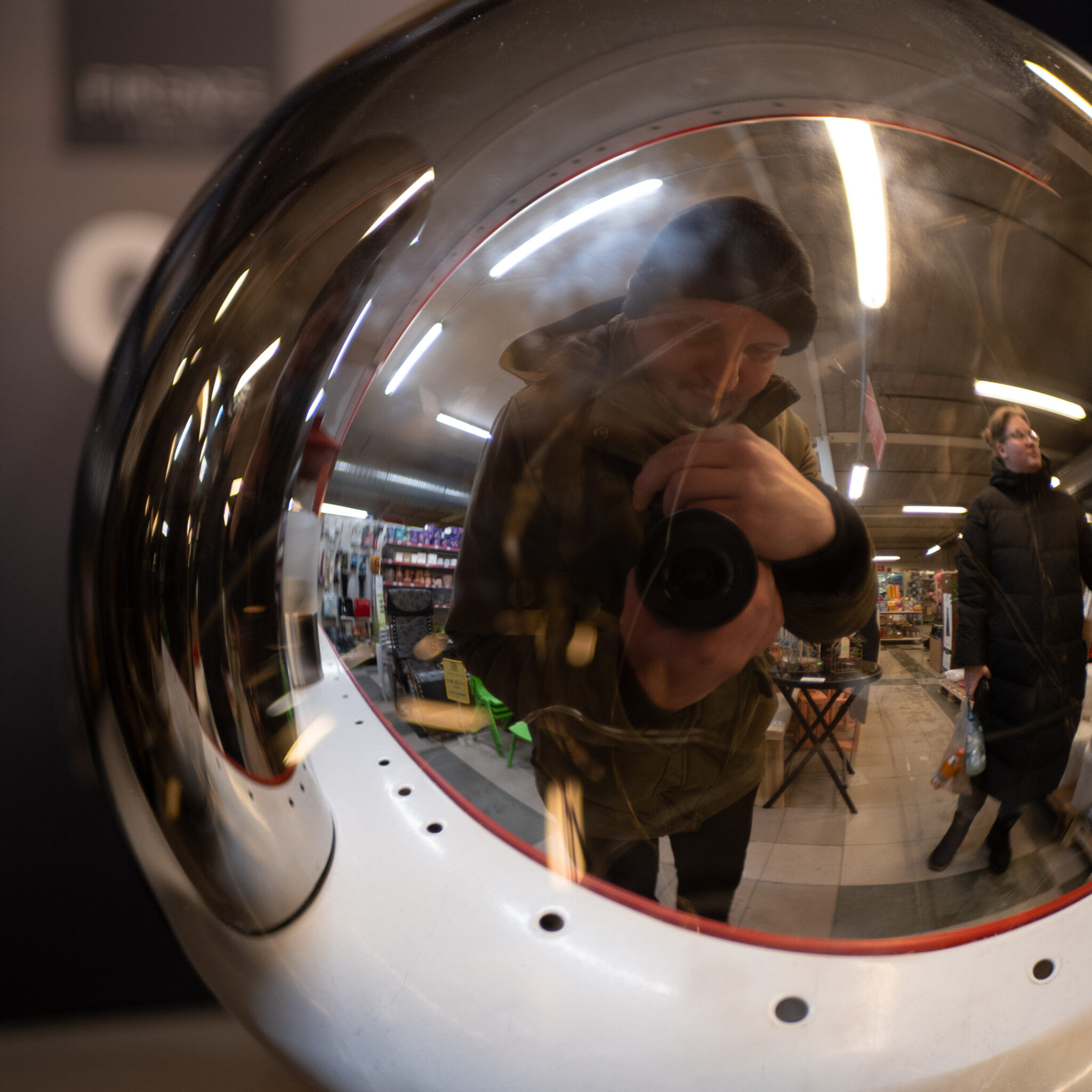 Mees teeb sfäärilisse peeglisse selfit.