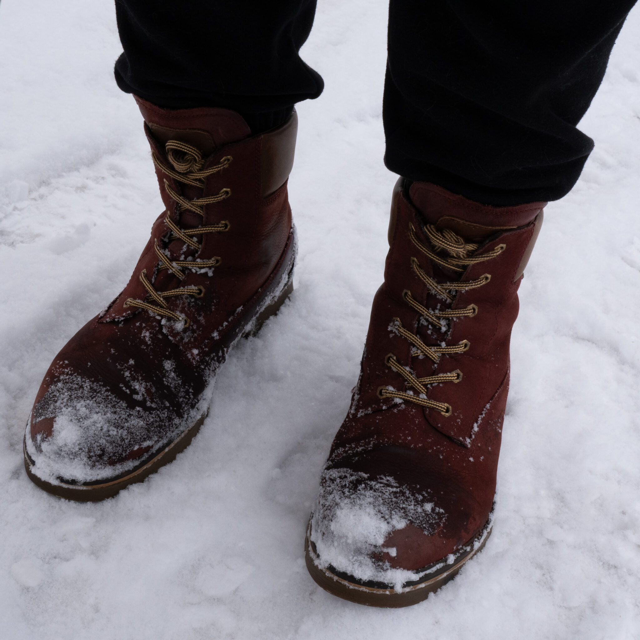 Inimene seisab lumes, jalas pruunid saapad.