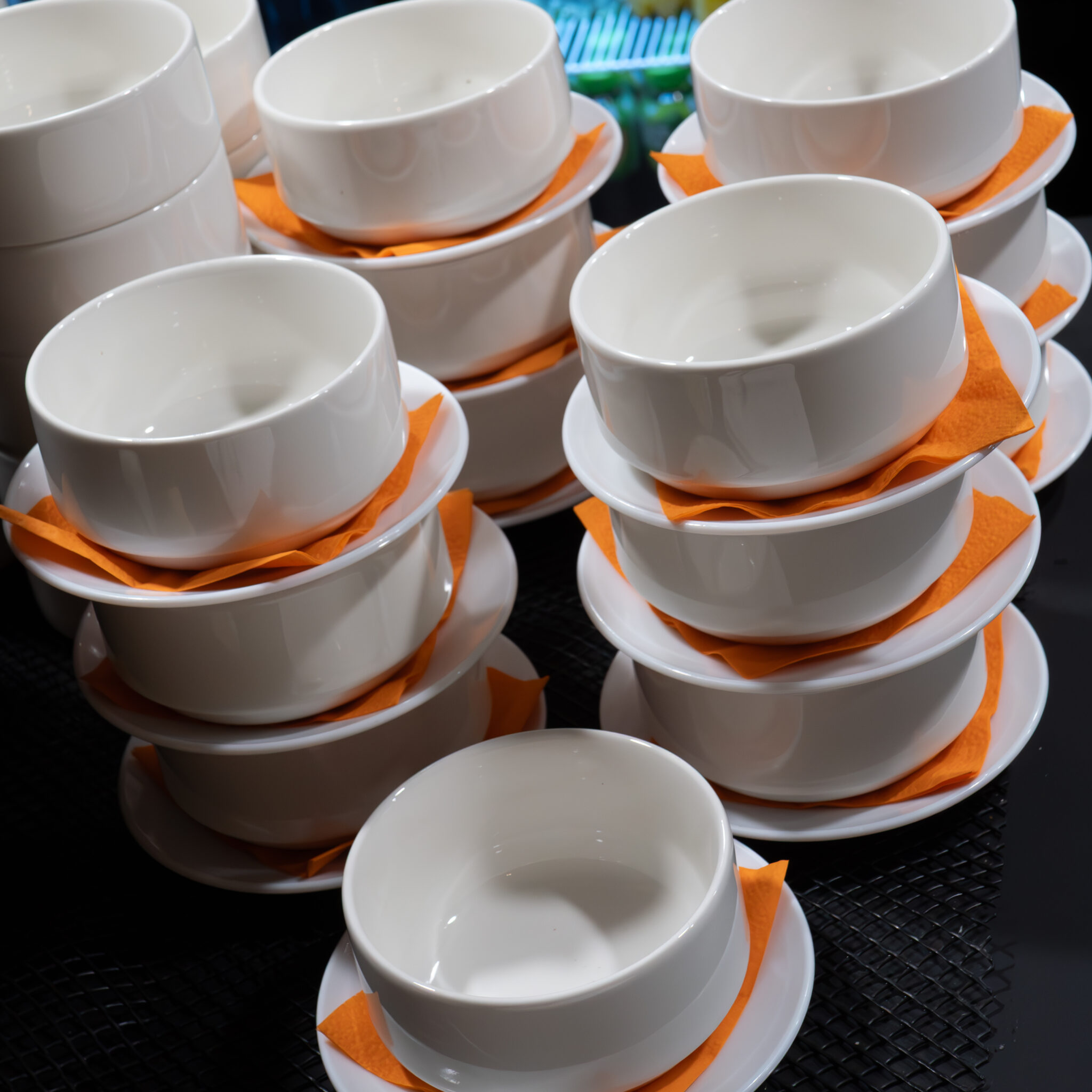 Virnad valgeid kausse oranžide salvrätikutega.