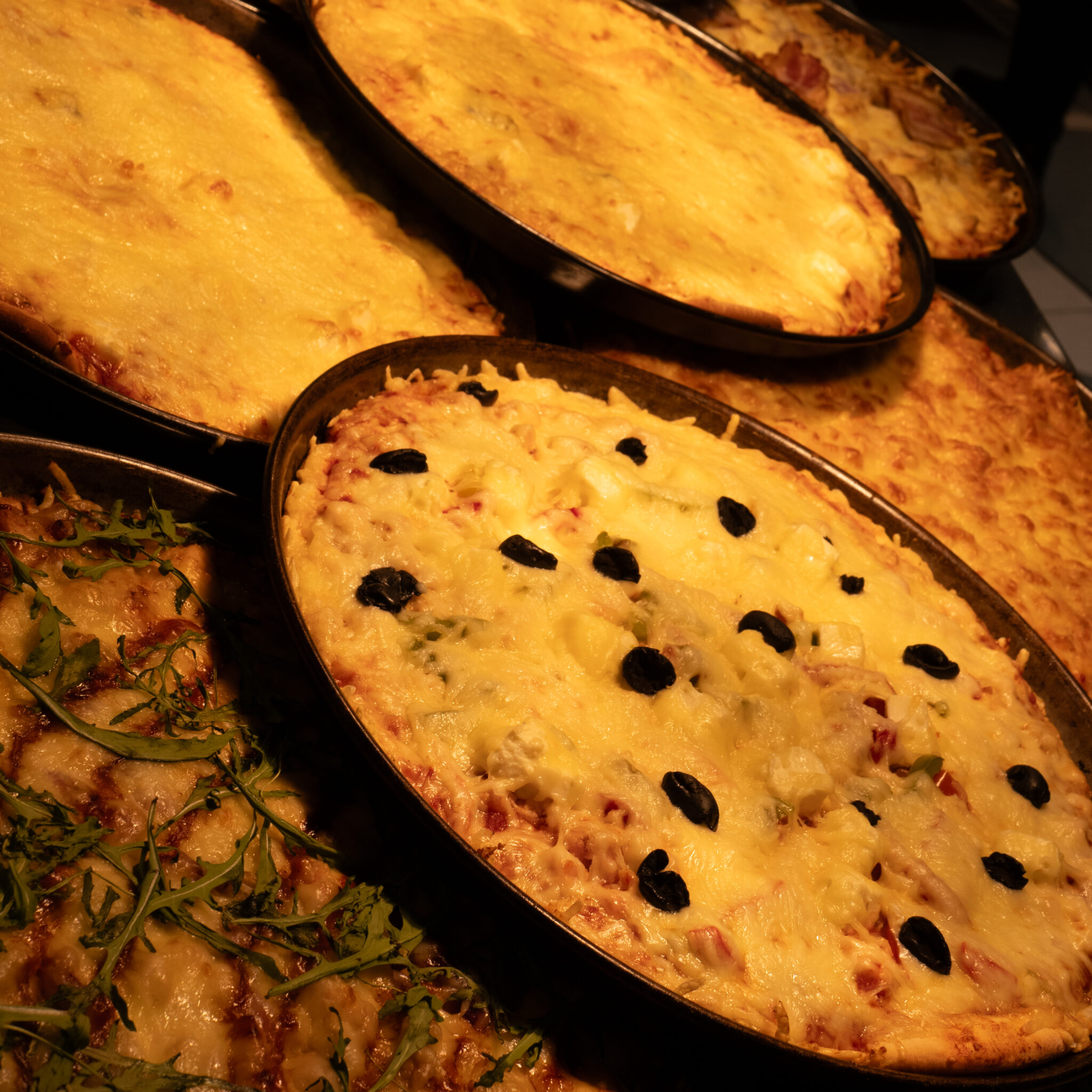 Mitmed pitsad juustu, oliivide ja ürtidega.