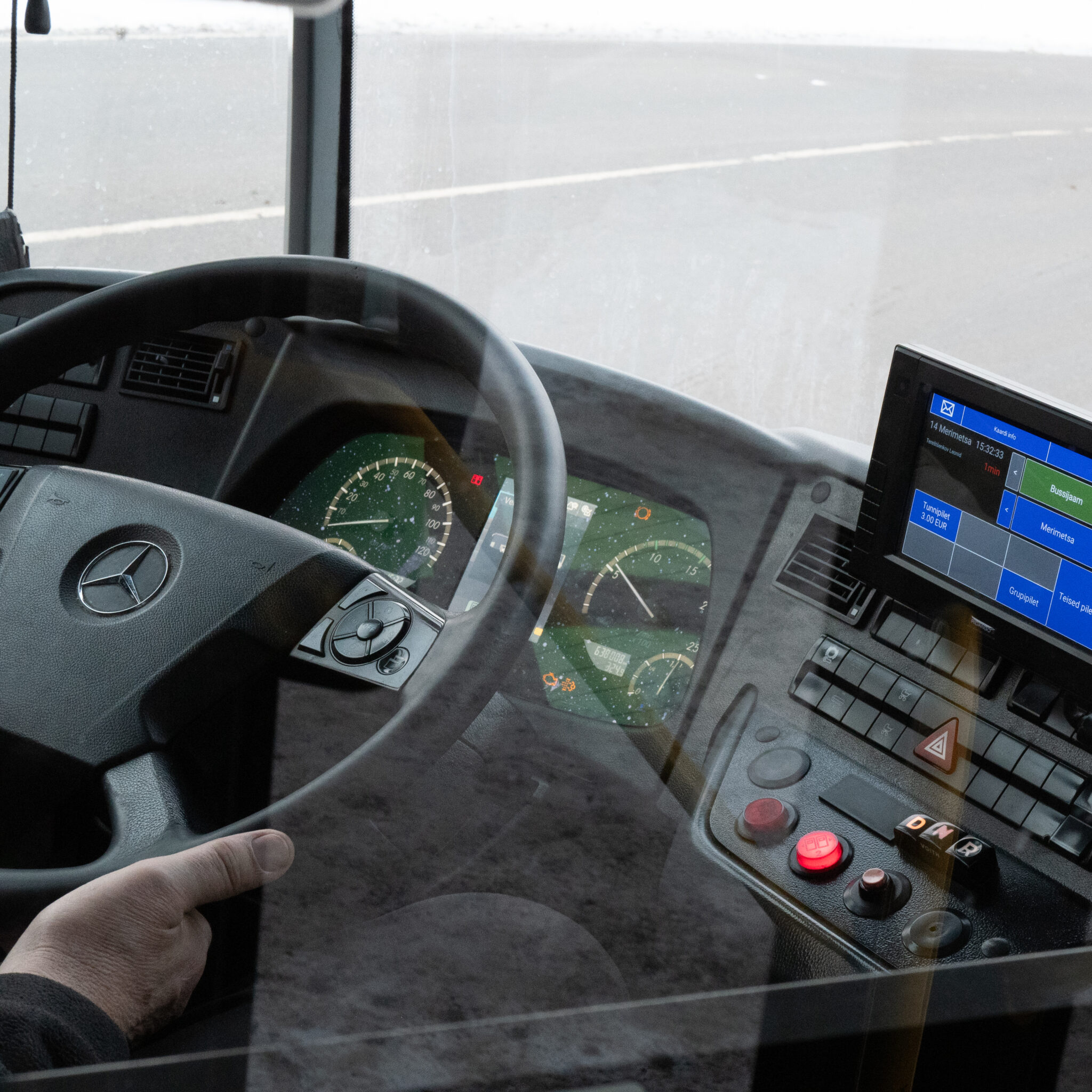 Mercedes-Benzi bussi armatuurlaud ja käsi roolil.