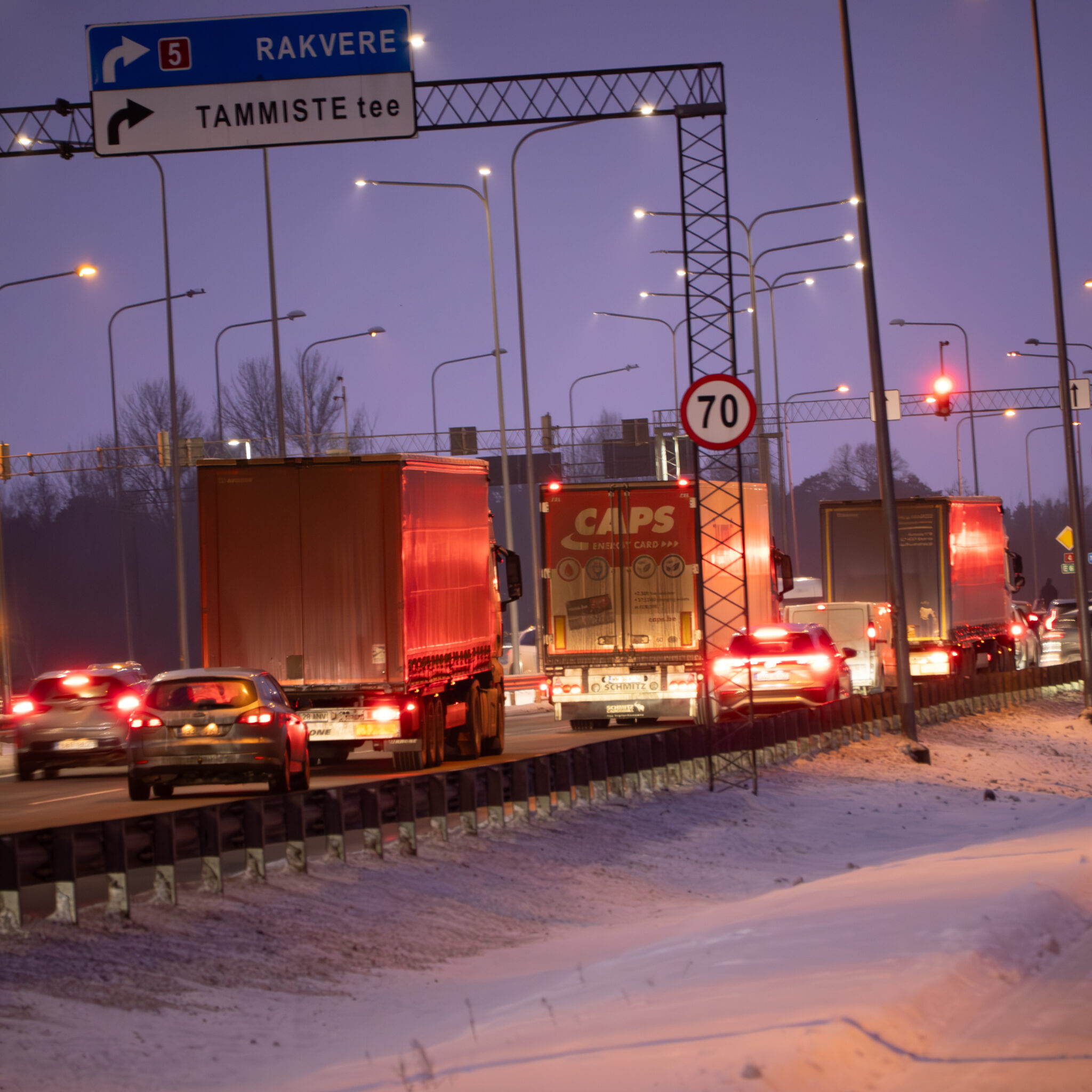 Liiklus lumisel maanteel videvikus, teeviit Rakvere suunas.