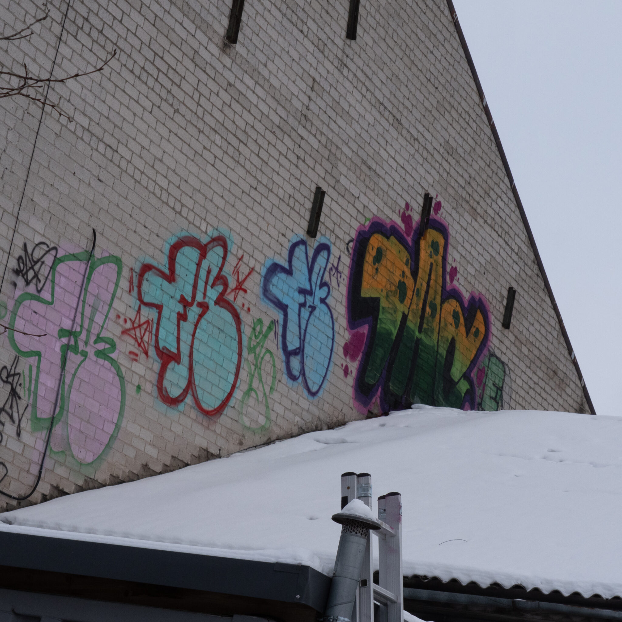 Grafiti tellisseinal, katusel lumi.