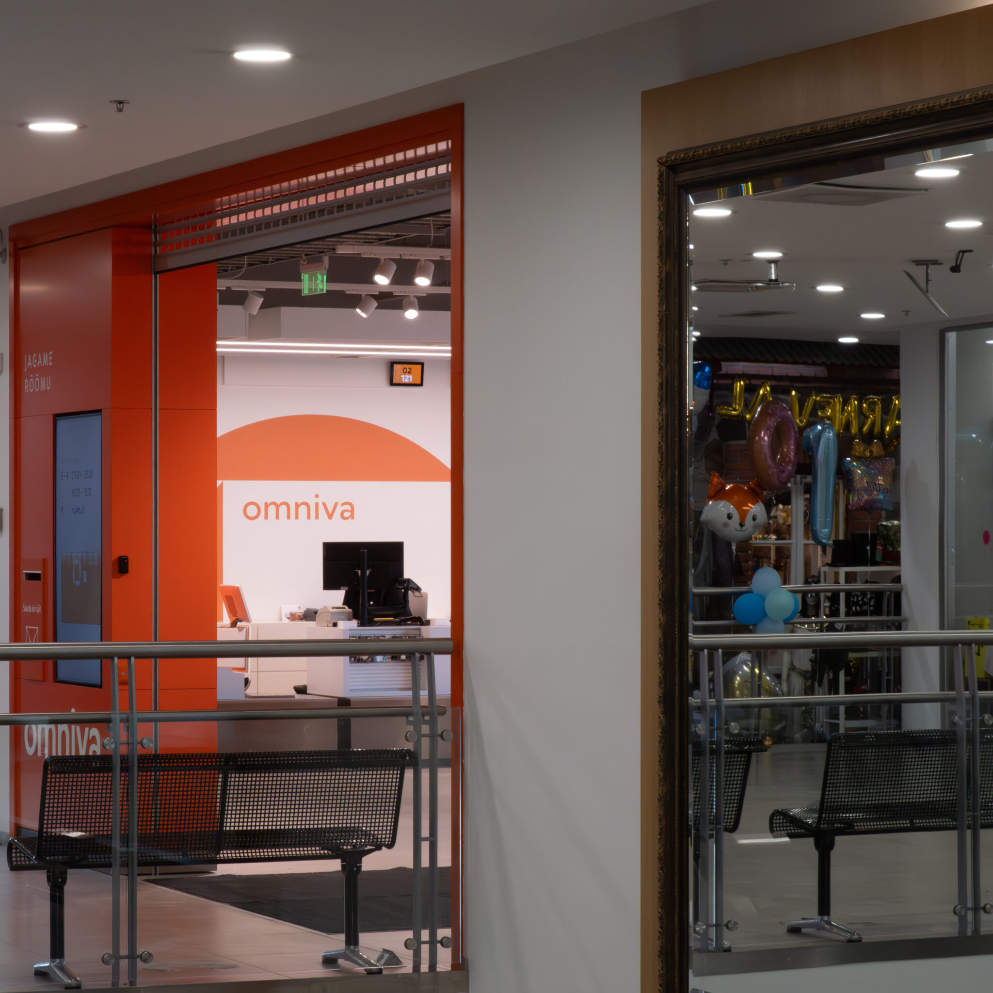 Omniva esindus oranžide detailide ja õhupallidega kaubanduskeskuses.