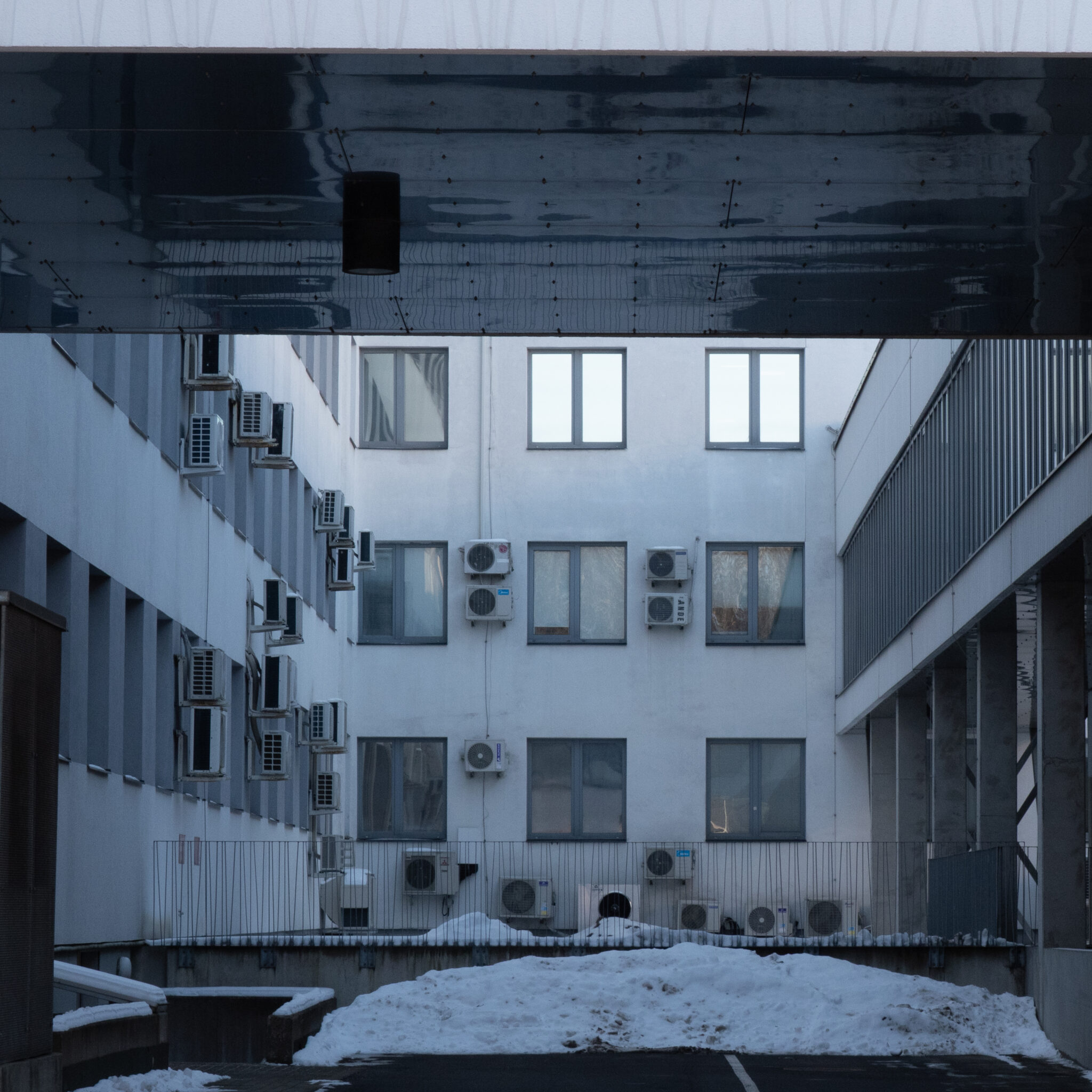 Moodne hoone kliimaseadmete ja lumise maapinnaga.