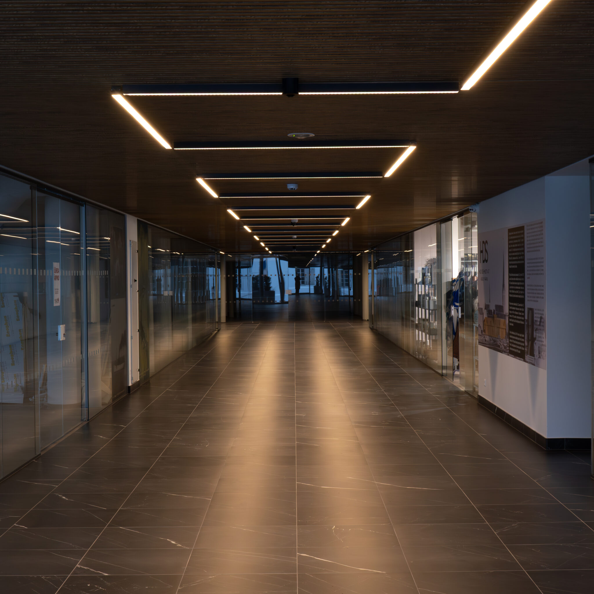 Moodne tühi koridor klaasseinte ja puitlaega.