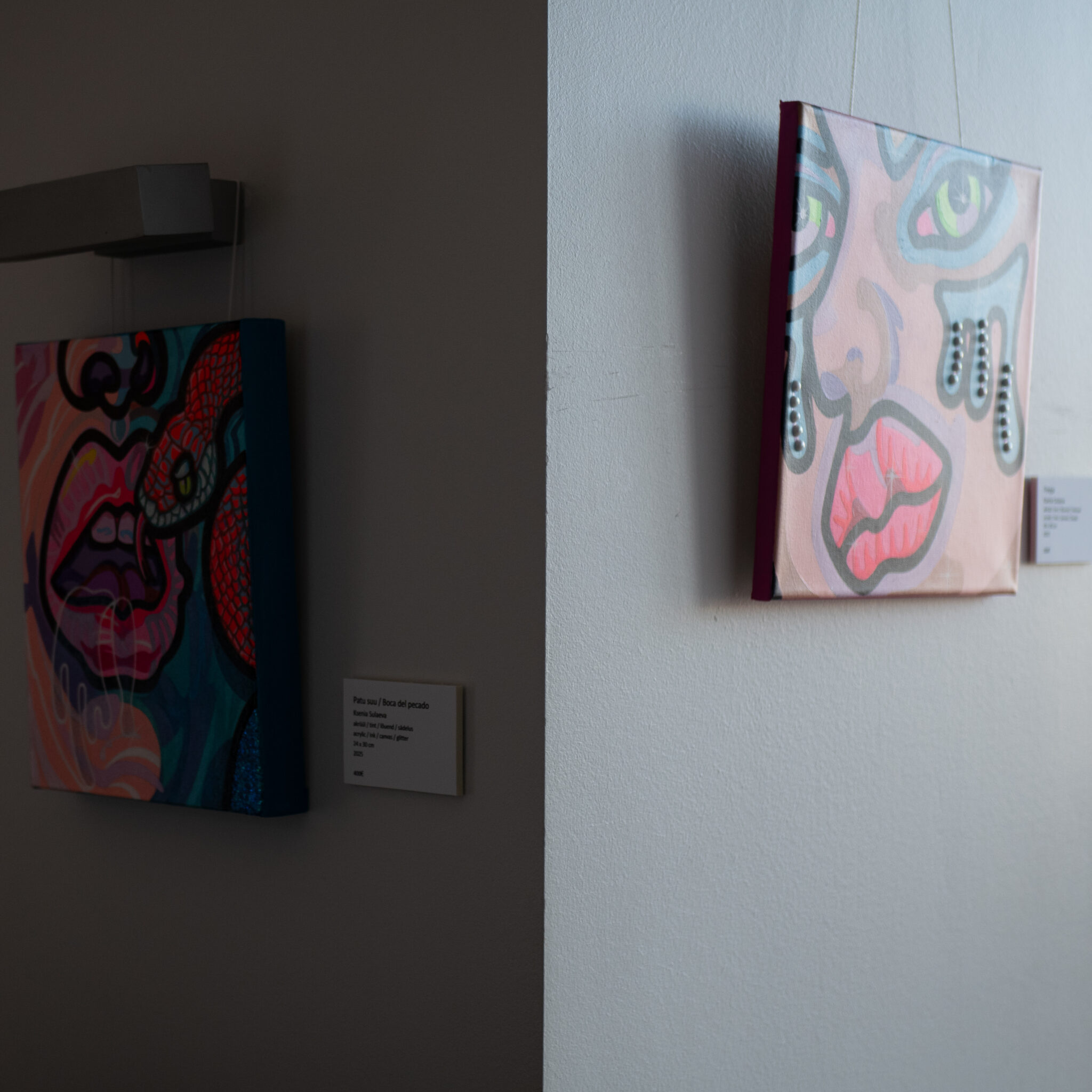 Seinal ripuvad kaks maali, ühel nägu ja teisel madu.