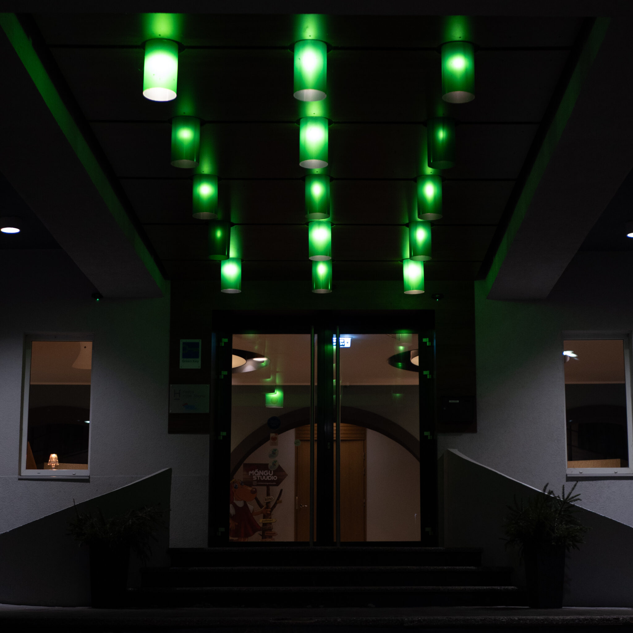 Rohelised tuled valgustavad öösel hoone sissepääsu.